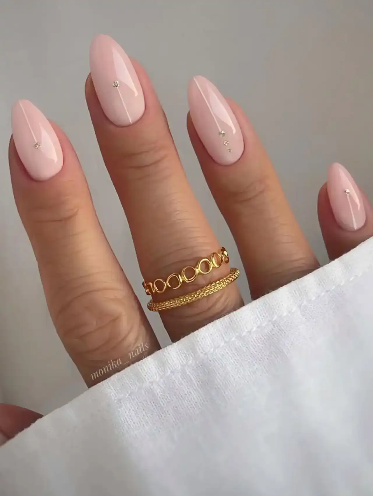 Soft blush pink nails with subtle glitter accents, highlighting nail art design 2025.