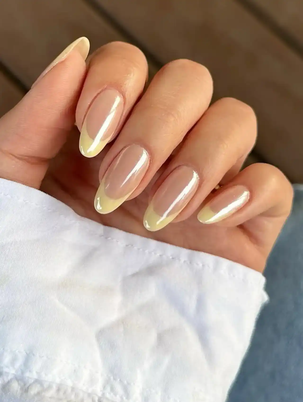 Almond-shaped nails with butter yellow French tips, part of nail art design 2025 trends.