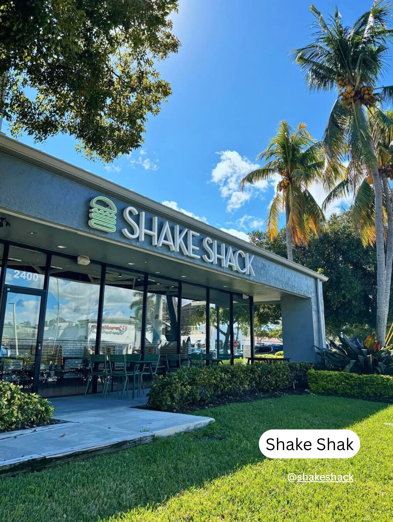 Shake Shack storefront with palm trees and outdoor seating, a popular pet friendly restaurant in Orlando.