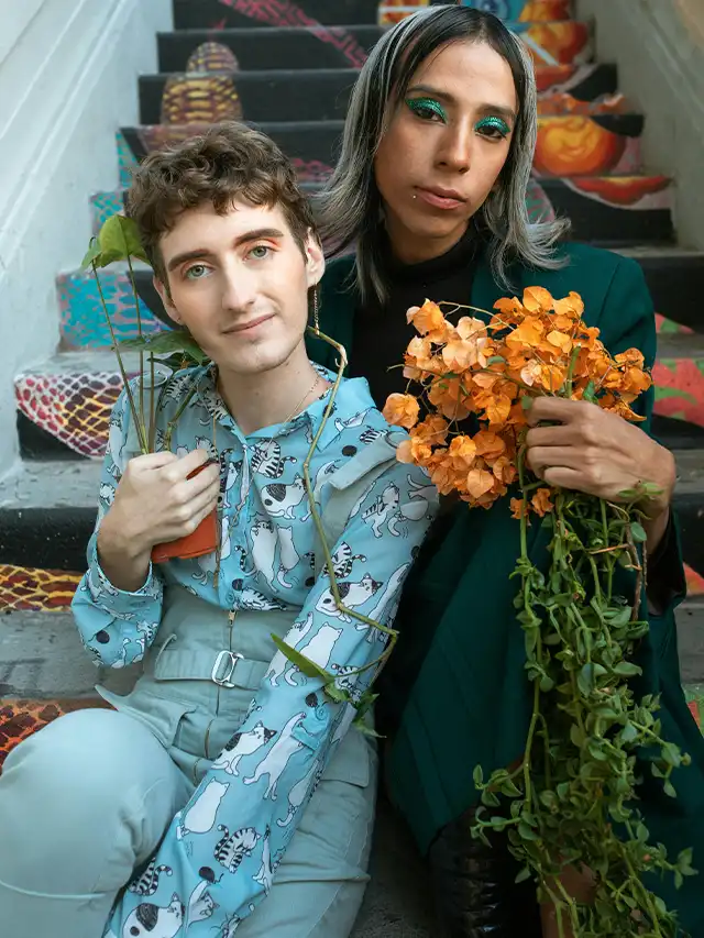 a man and woman sitting on stairs with flowers