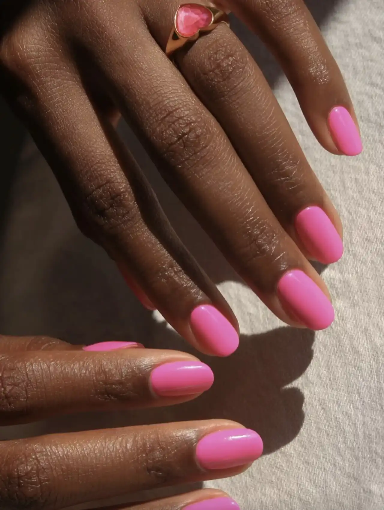 Solid neon pink nails with a glossy finish