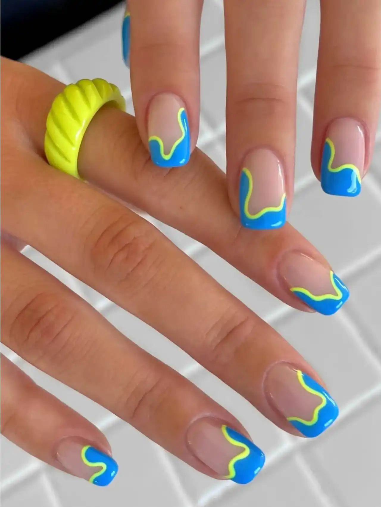 Blue and neon yellow wavy line nails on a square manicure style
