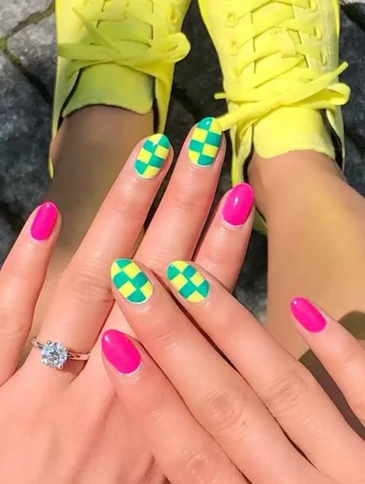 Neon nails with green and yellow checkerboard design paired with pink polish