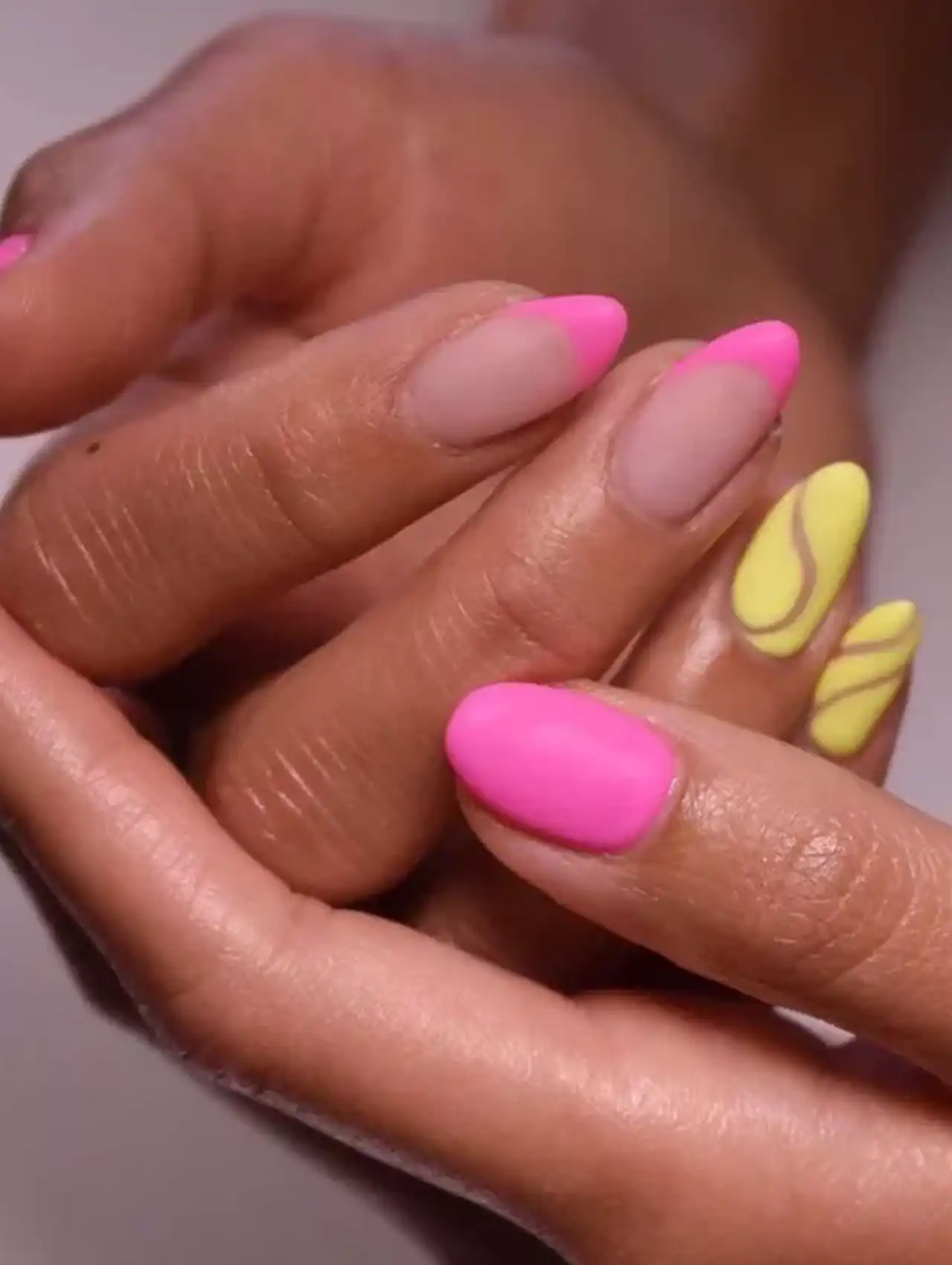 Matte neon nails with pink polish and yellow accent designs