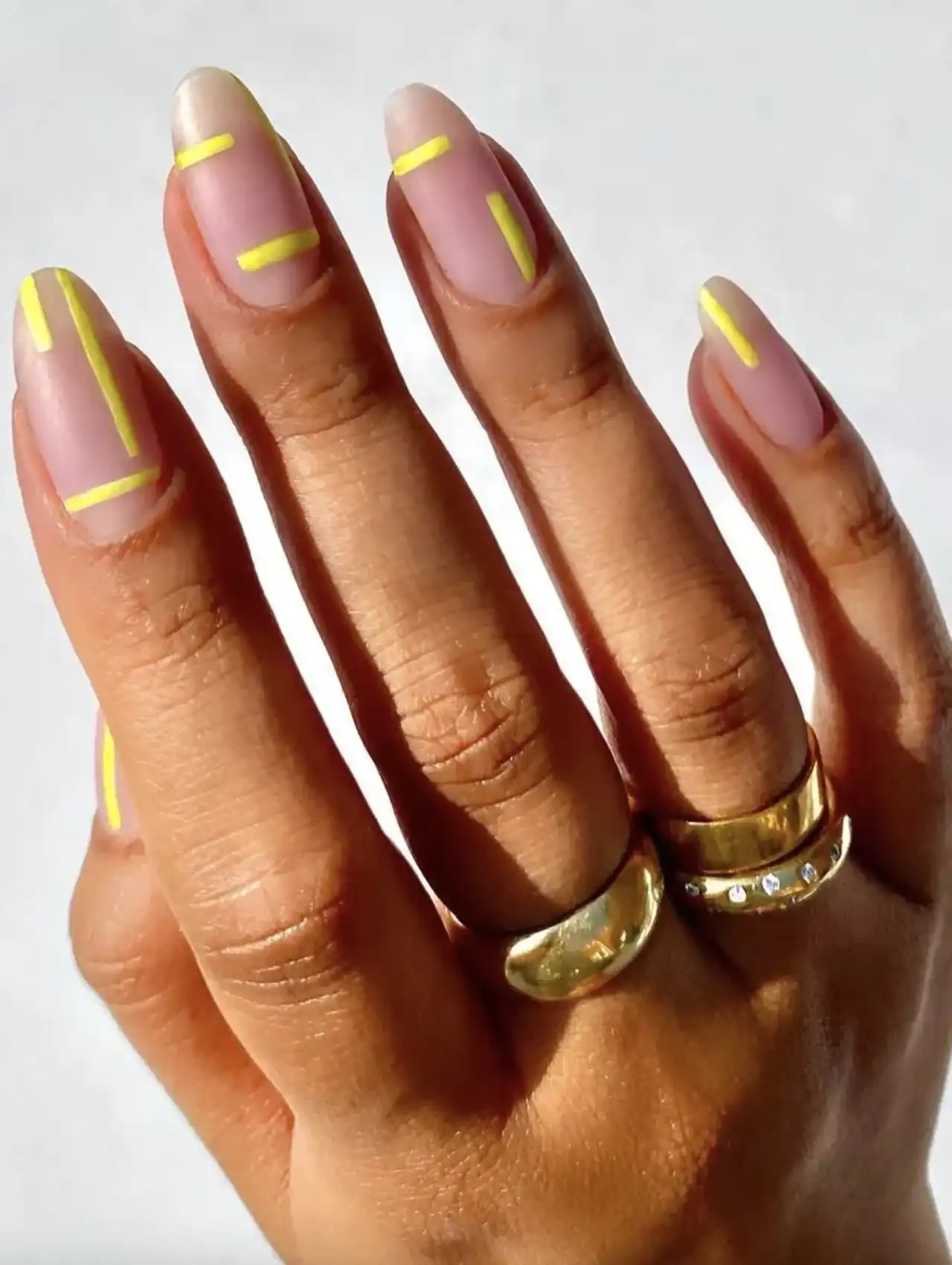 Neon nails with minimalist yellow line accents on nude base