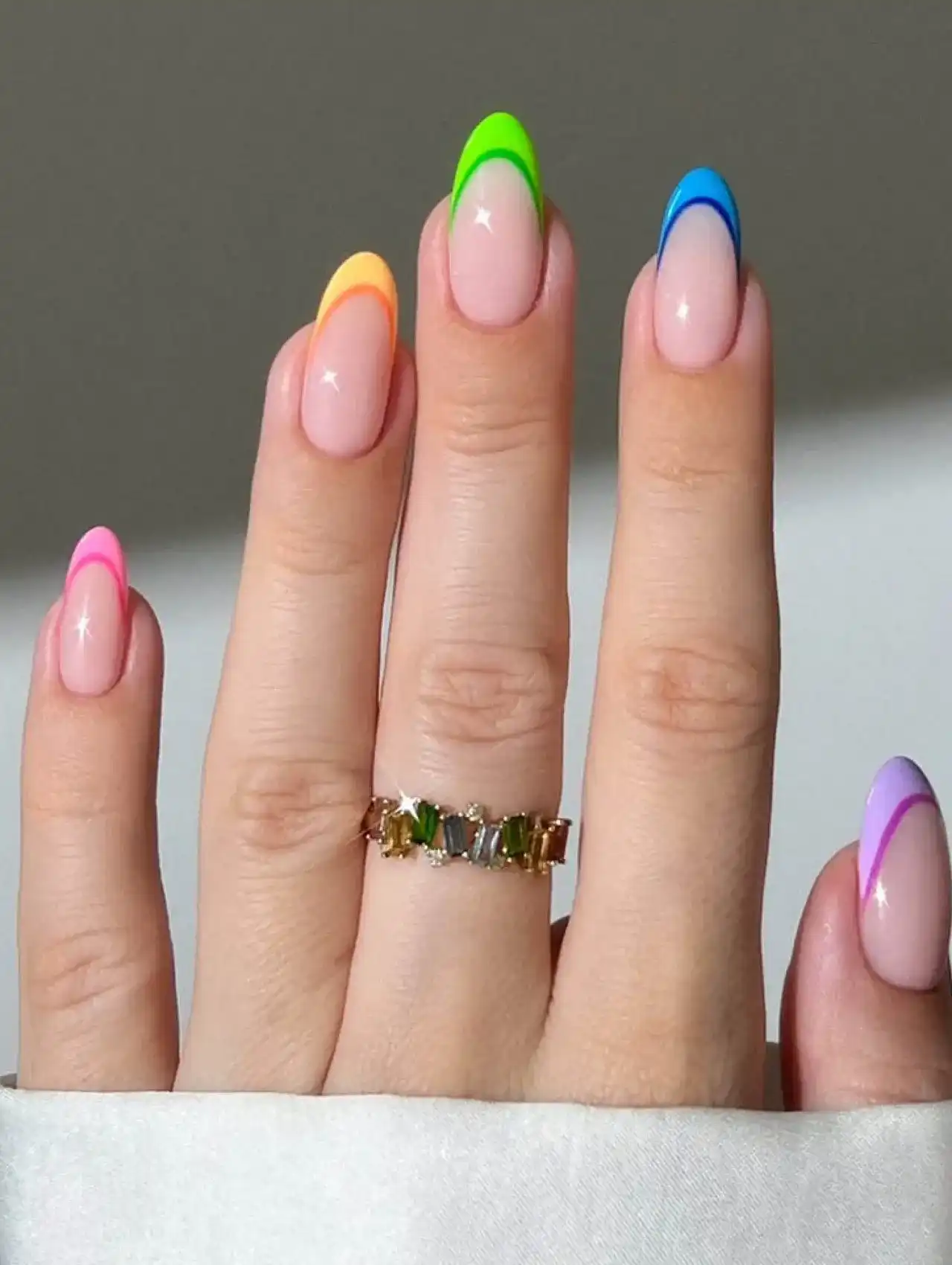 Neon French tip nails in pink, orange, green, blue, and purpl