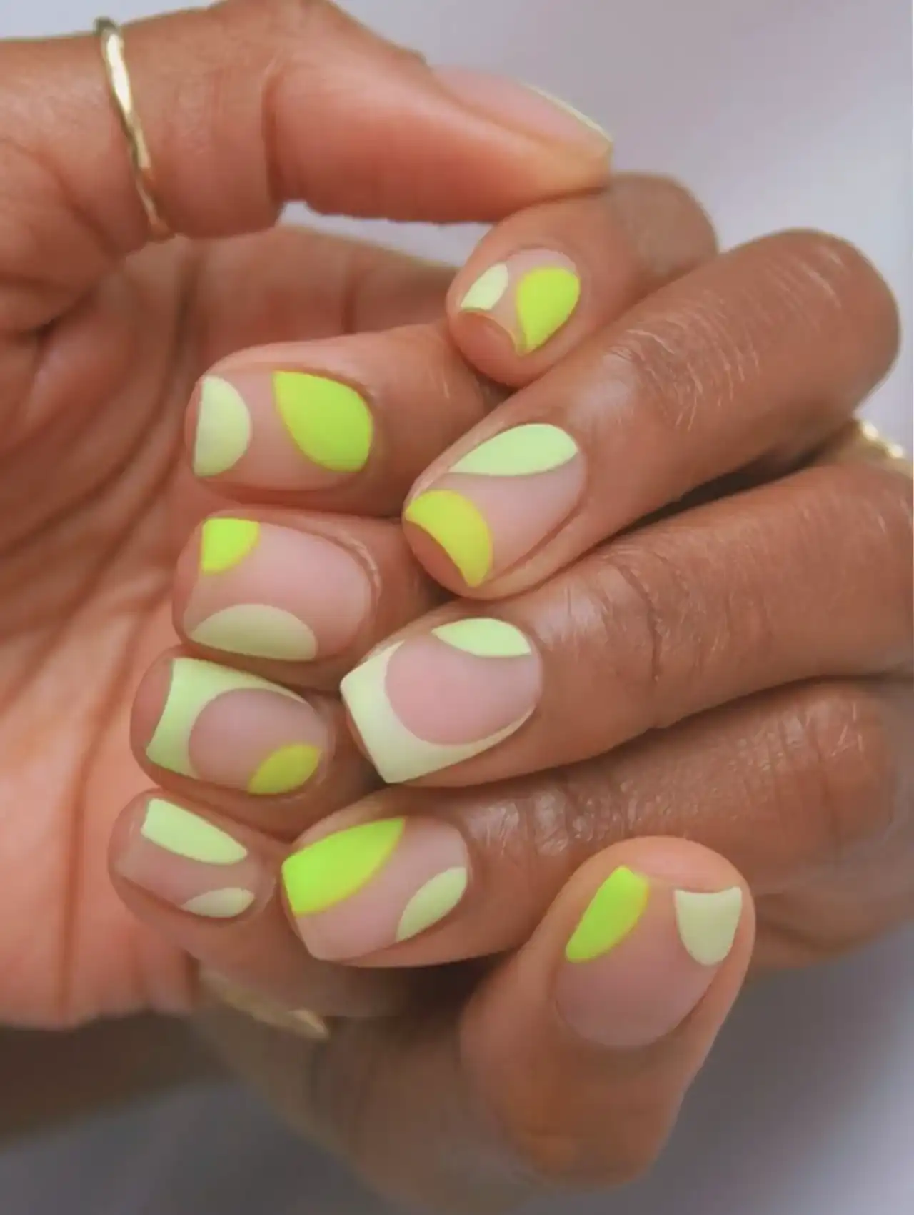 Short neon nails with soft lime green and nude pattern