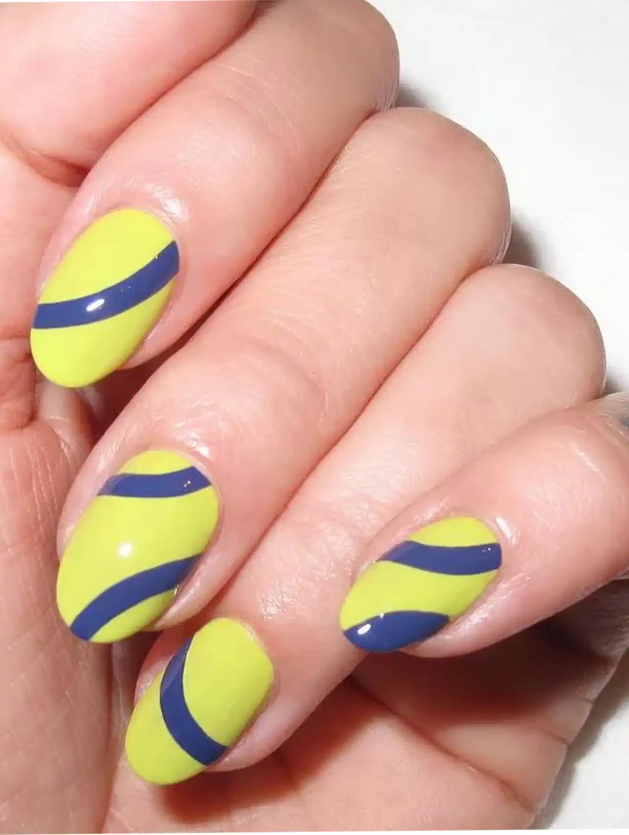Neon nails in tennis ball yellow with navy blue swirls