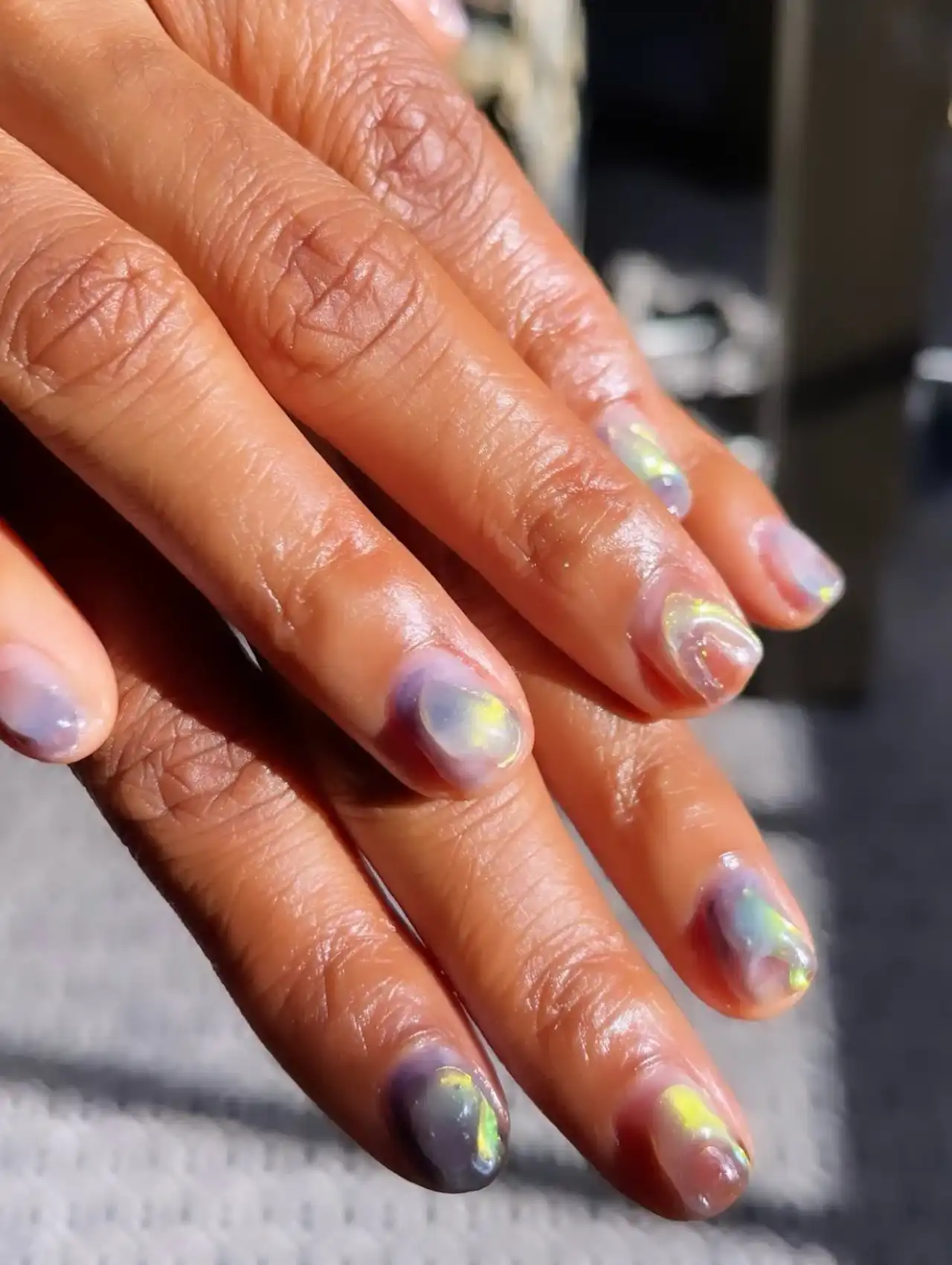Ayo Edebiri with 3D iridescent rainbow teardrop celebrity nails under natural light