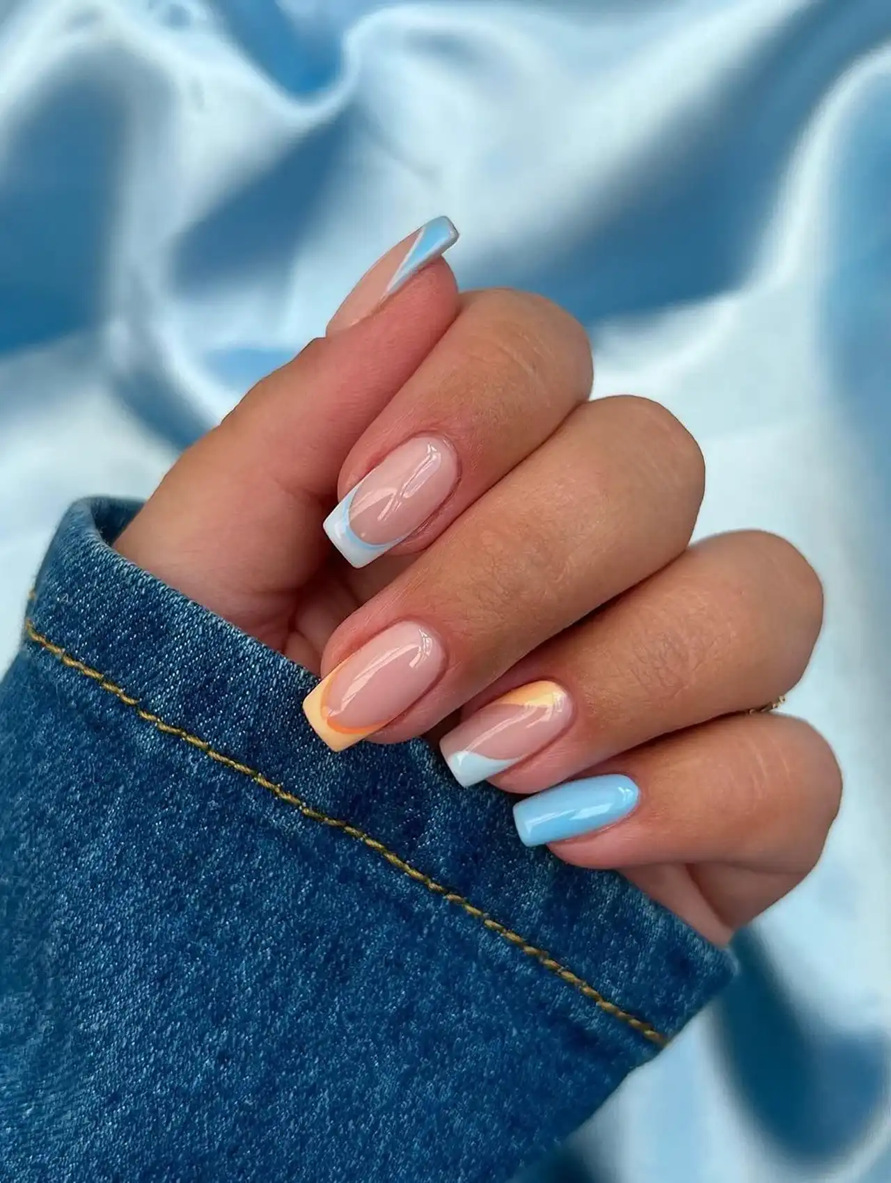 Blue, white, and orange French tips on short nails, inspired by summer skies nail designs