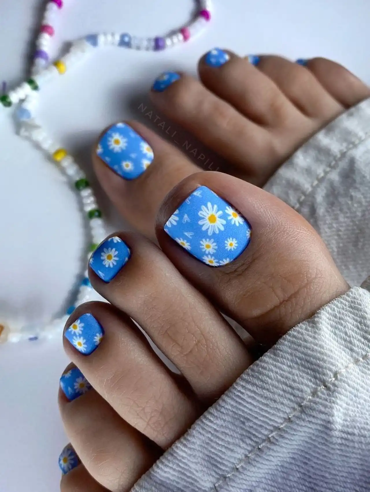 Blue summer toe nail design with white daisy floral pattern