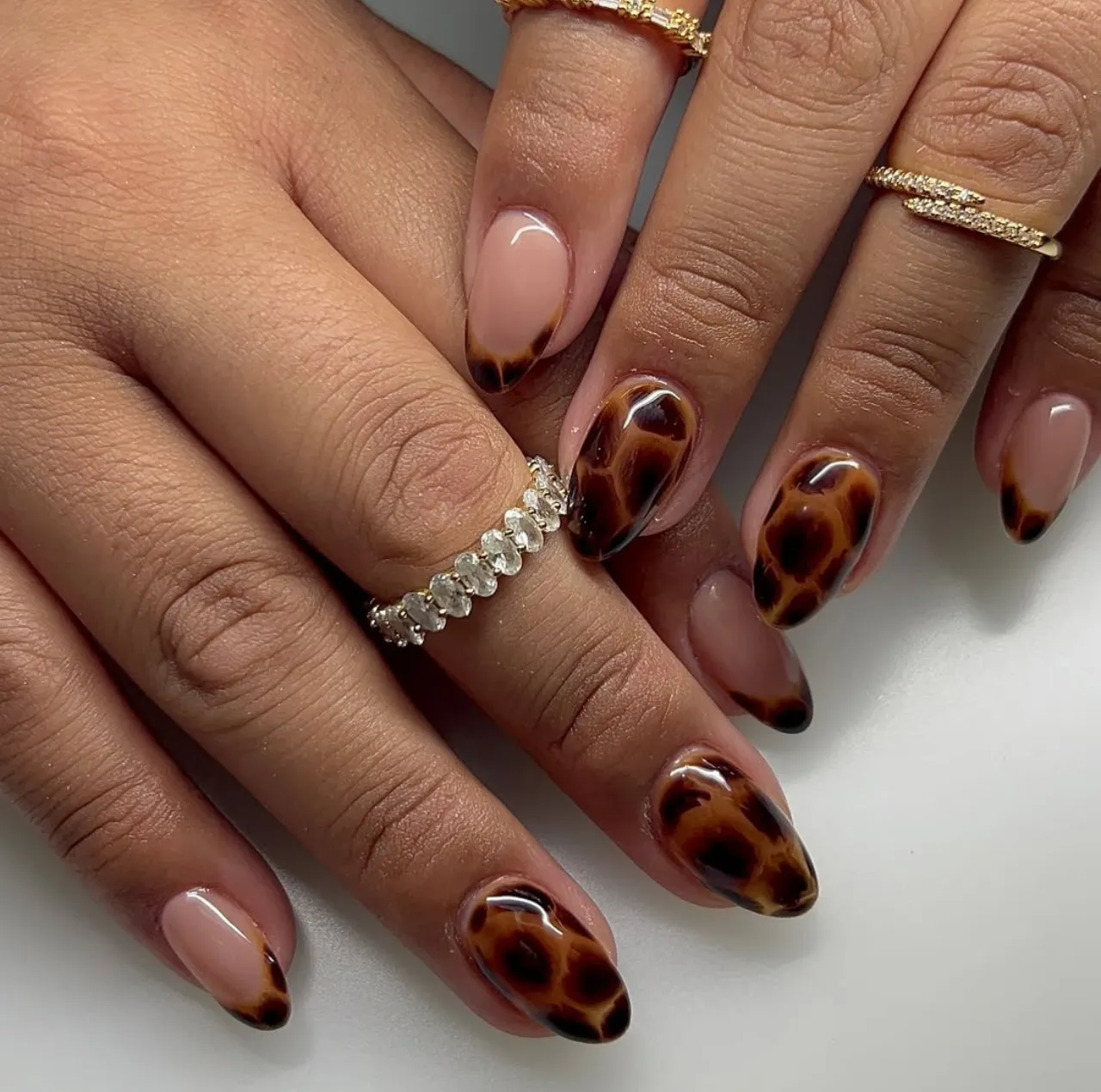 Diseño de uñas animal print estilo carey en tonos marrón y negro.