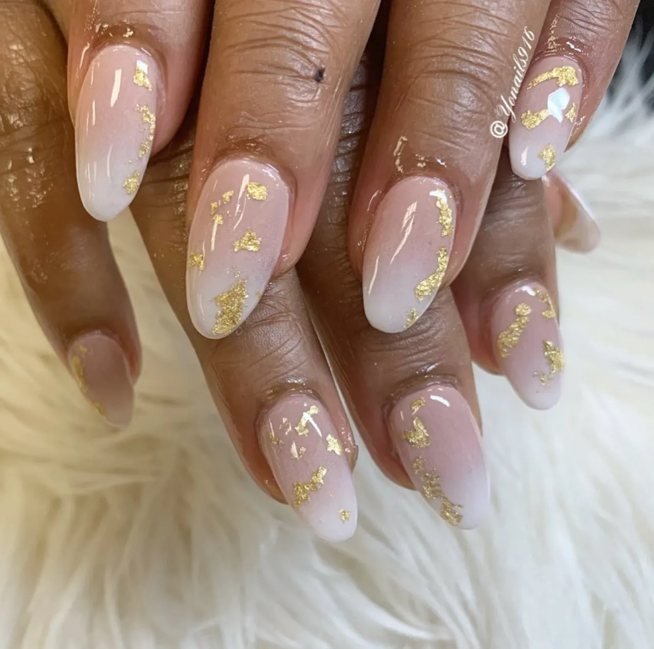 Diseño de uñas con envoltorios dorados sobre base nude y efecto difuminado.
