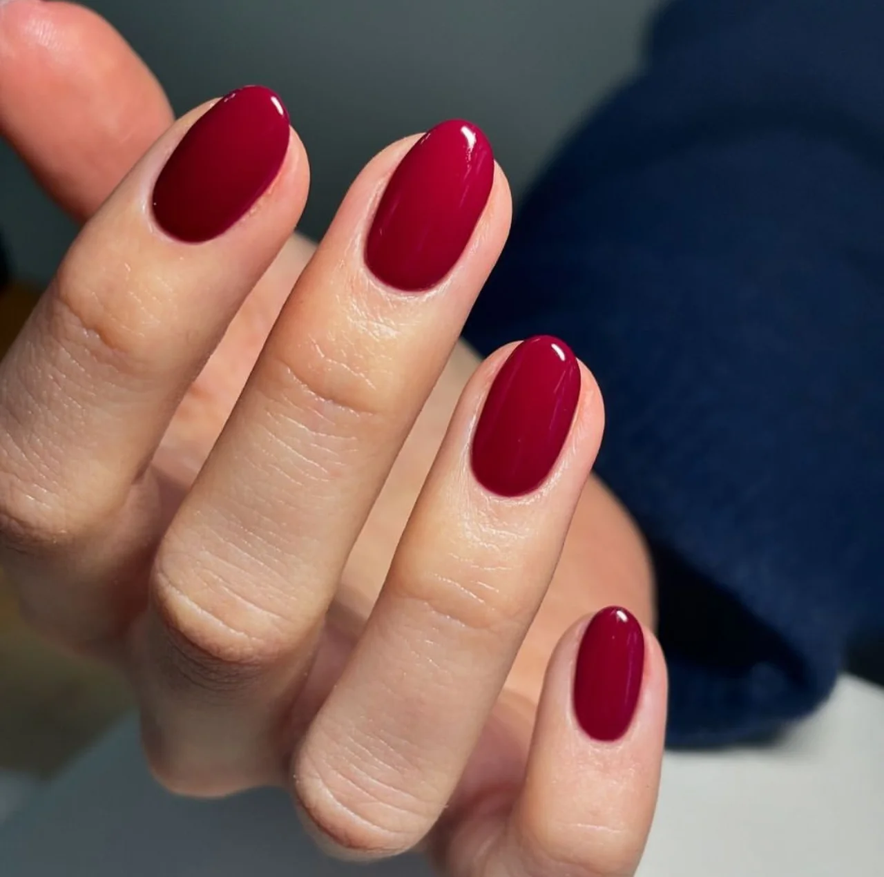 Diseño de uñas con esmalte básico en tono rojo intenso.