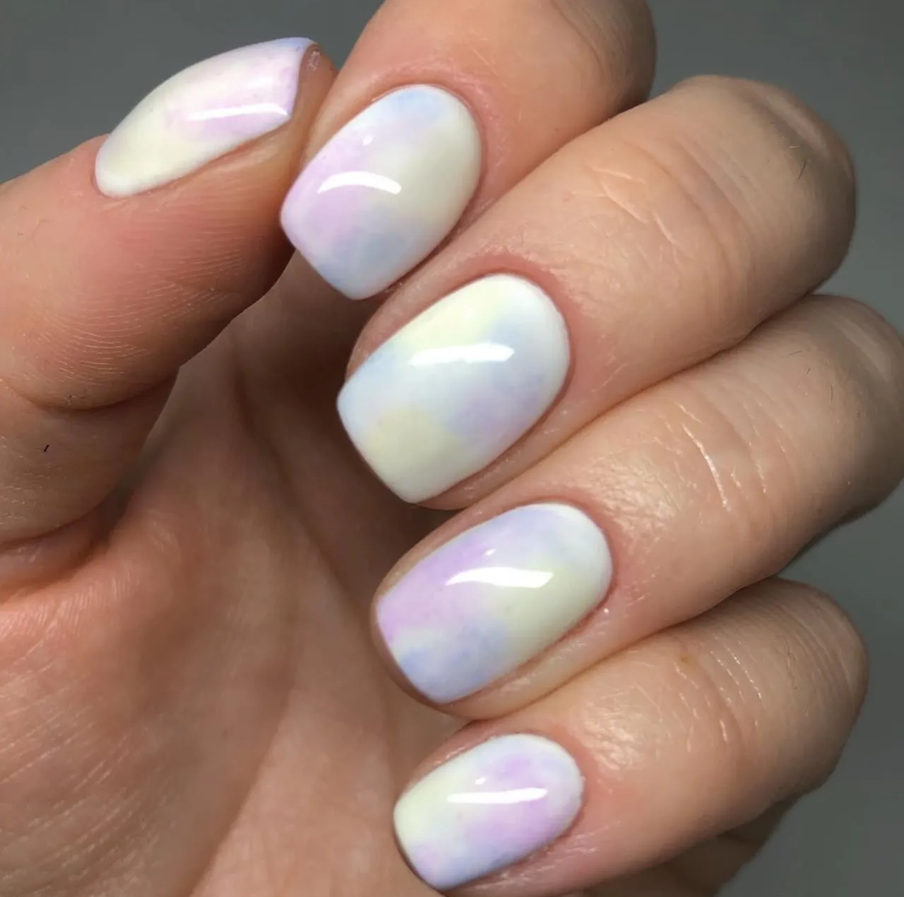 Diseño de uñas esponjado en tonos pastel con efecto degradado suave.
