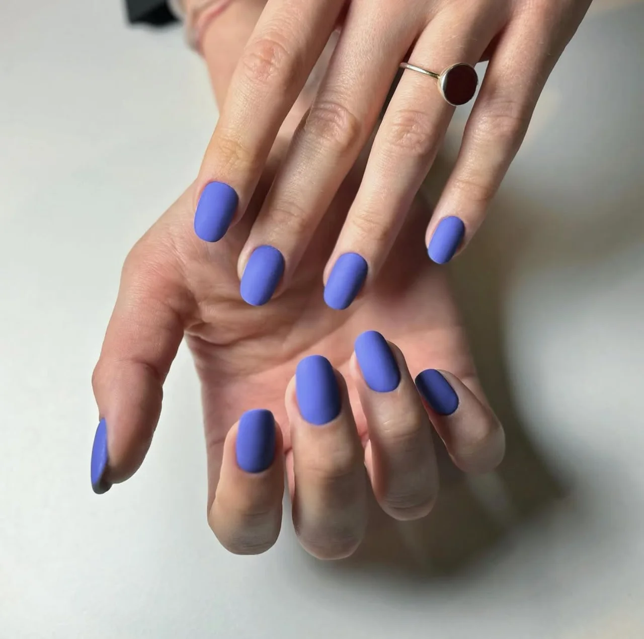Diseño de uñas en tono morado mate con acabado liso y elegante.