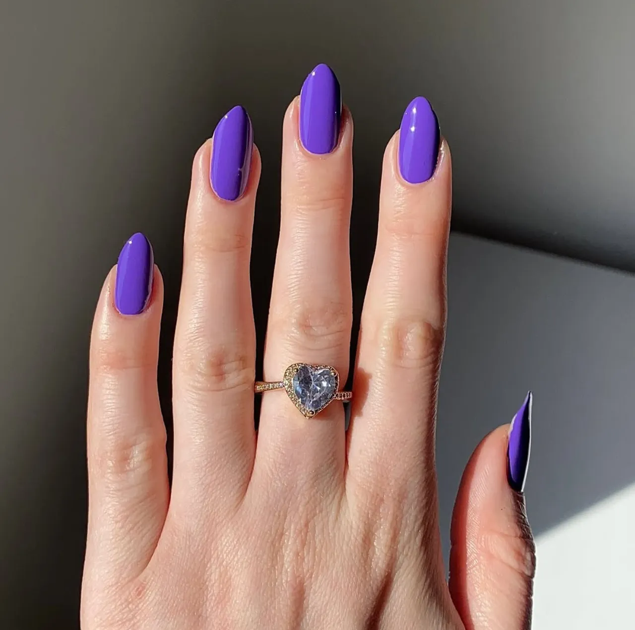 Diseño de uñas de gel en tono morado brillante.