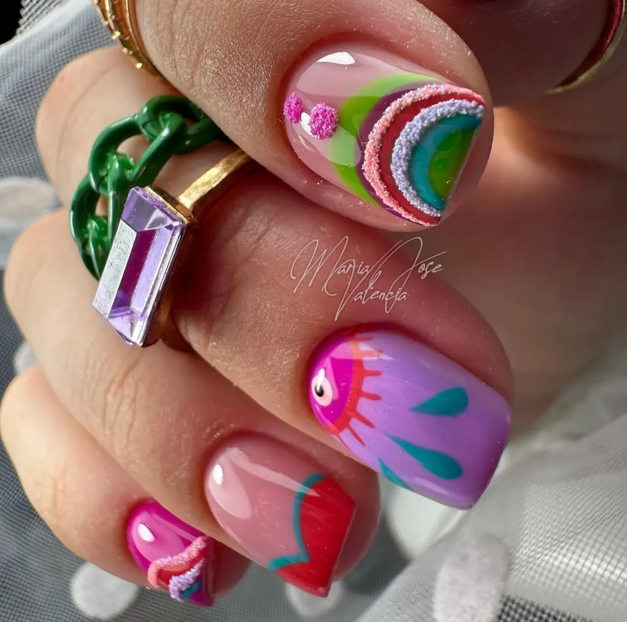 Diseño de uñas de humor con colores vibrantes, texturas en relieve y estilo creativo.