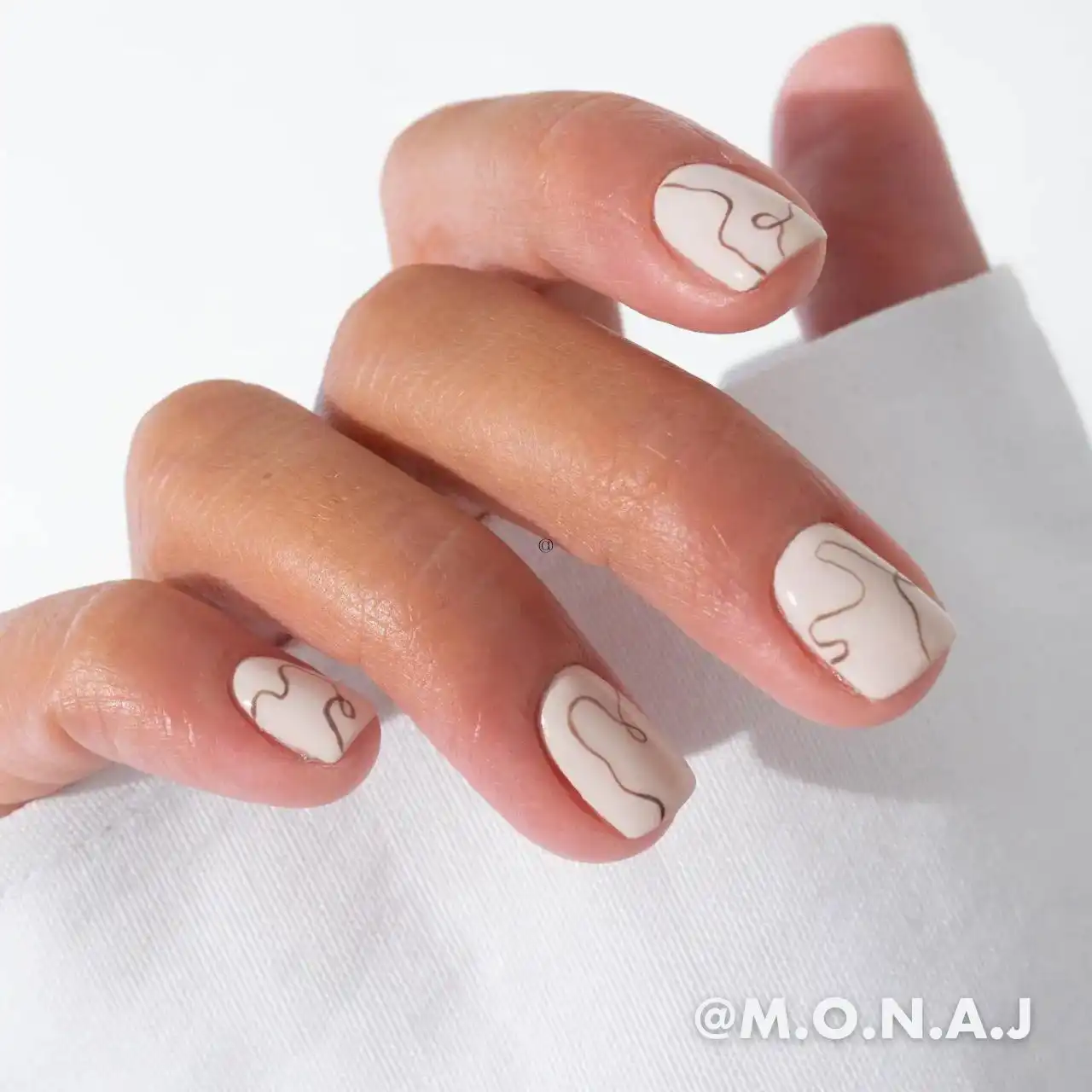 Diseños de uñas acrílicas abstractas en color blanco con líneas artísticas minimalistas.