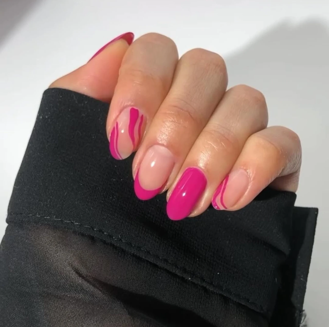 Diseños de uñas acrílicas con patrón rosa y detalles ondulados sobre base nude.
