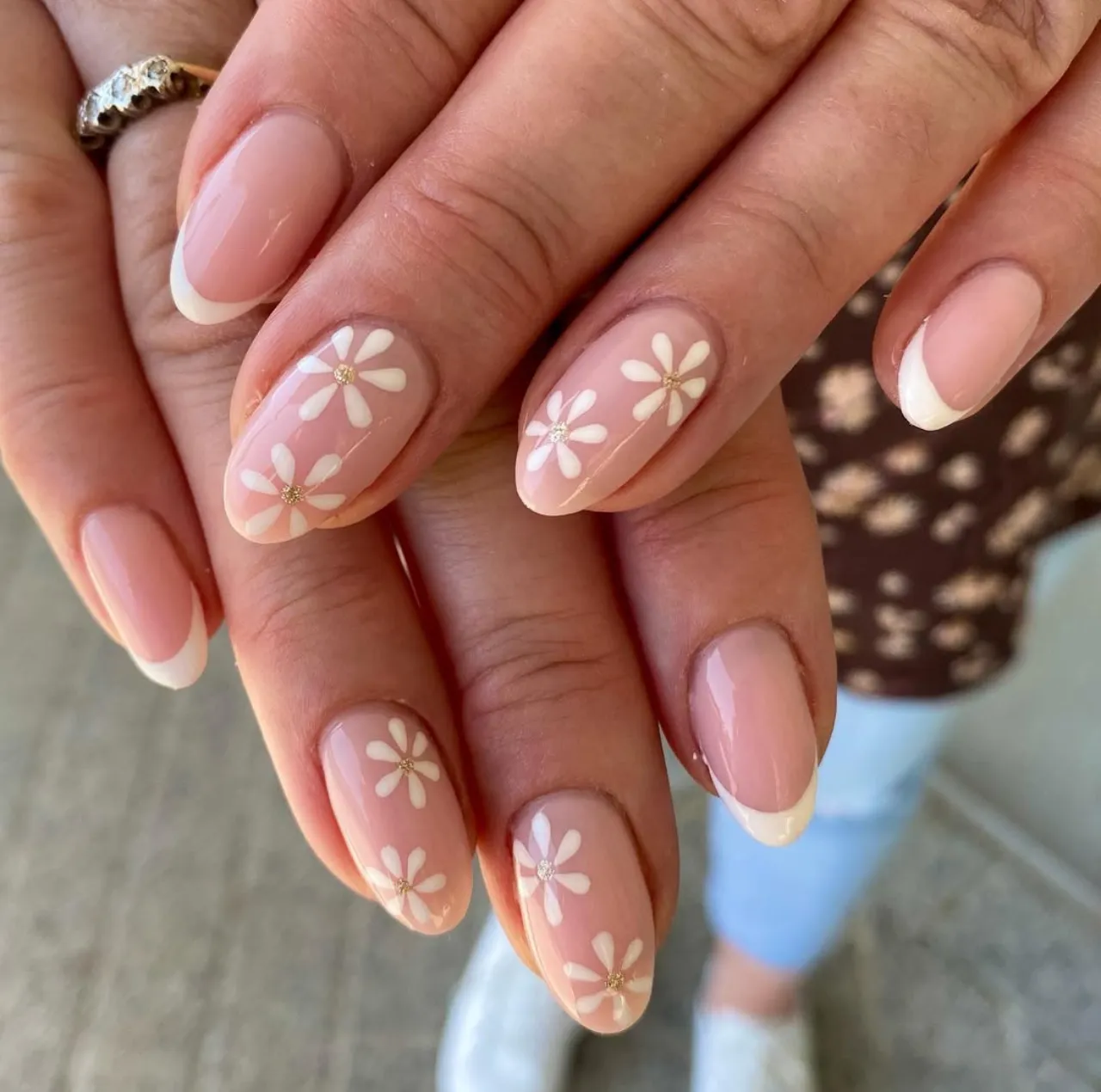 Diseños de uñas acrílicas con flores blancas estilo margarita sobre base nude.