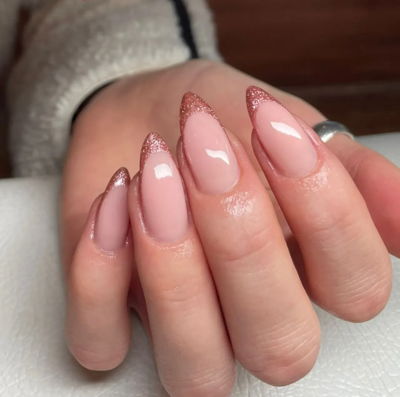 Diseños de uñas acrílicas con puntas francesas en rosa nude y glitter rosado.