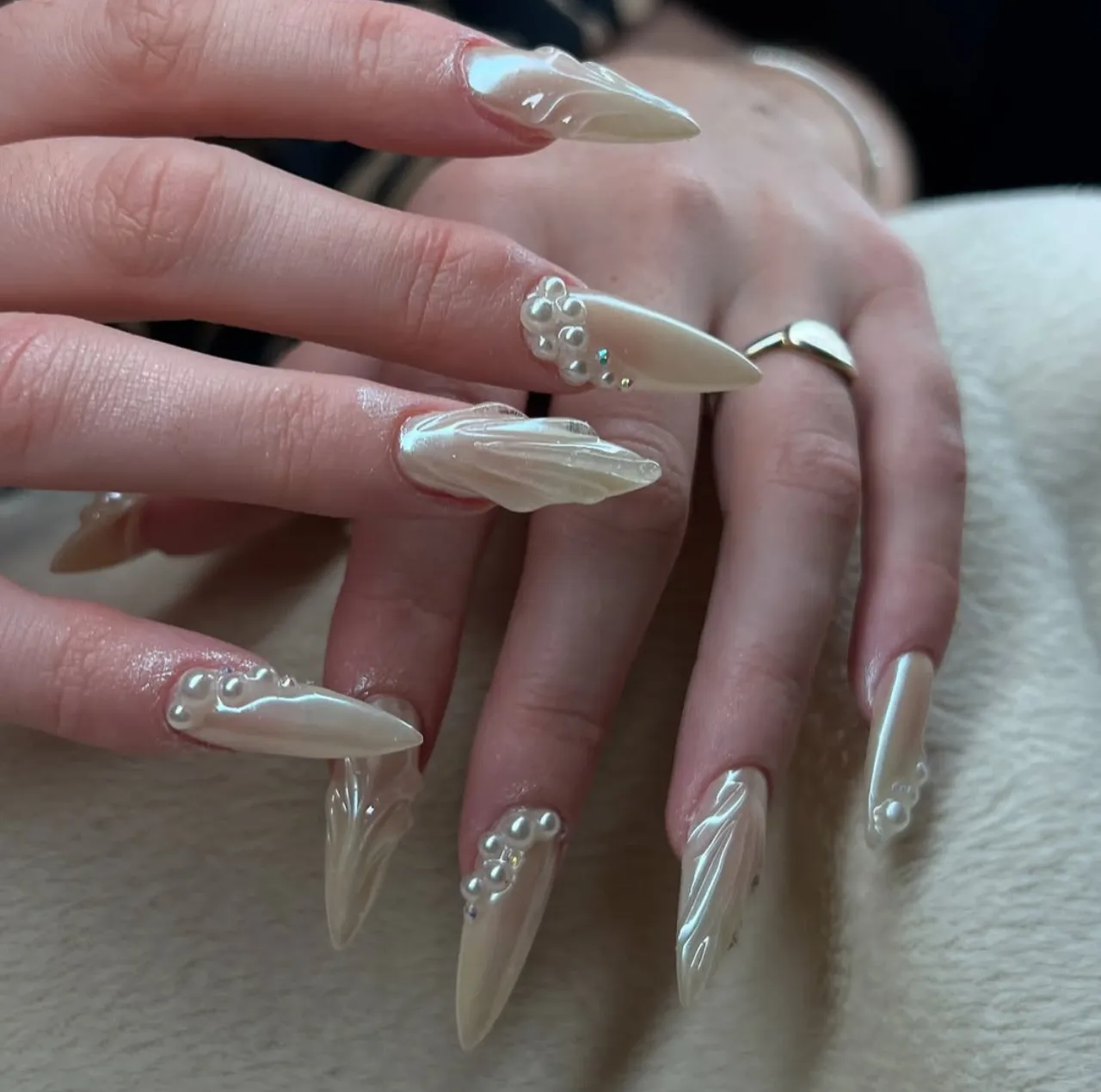 Diseños de uñas acrílicas estilo sirena con acabado nacarado y perlas decorativas.