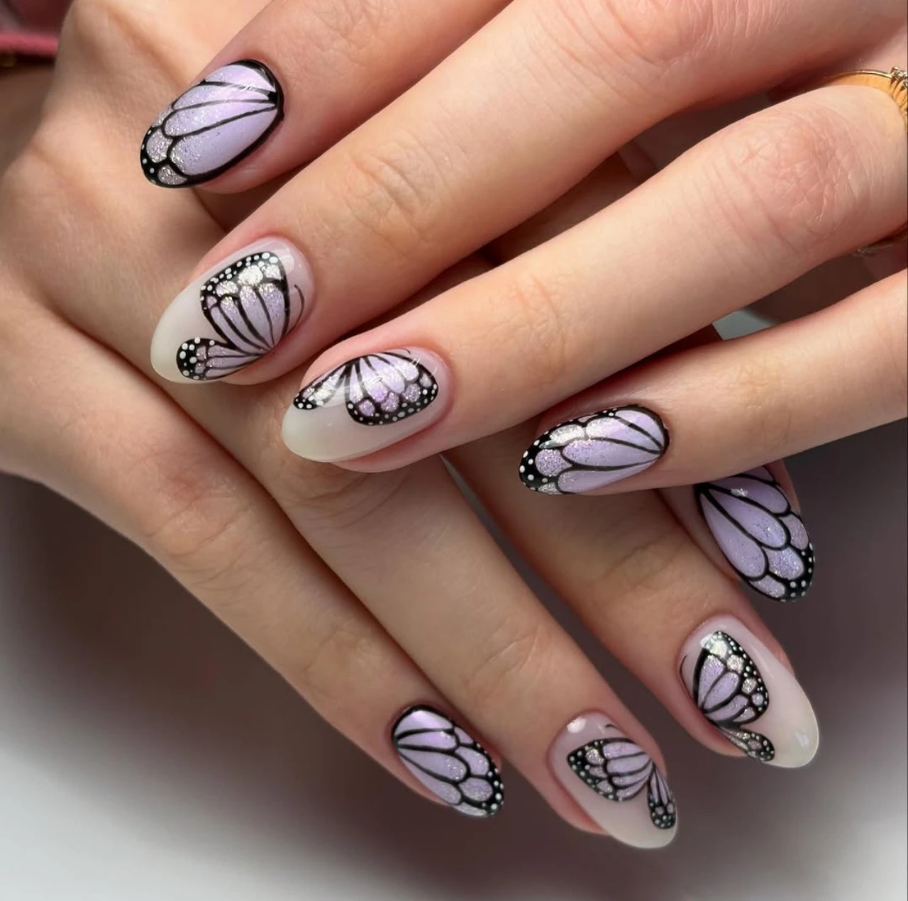 Diseño de uñas mariposa con efecto glitter en tonos lilas – diseños de uñas acrílicas.