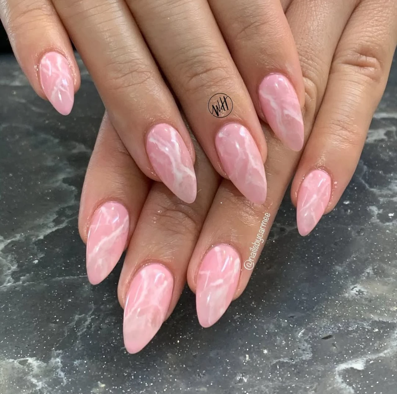 Diseños de uñas acrílicas mármol rosado con vetas blancas y acabado brillante.