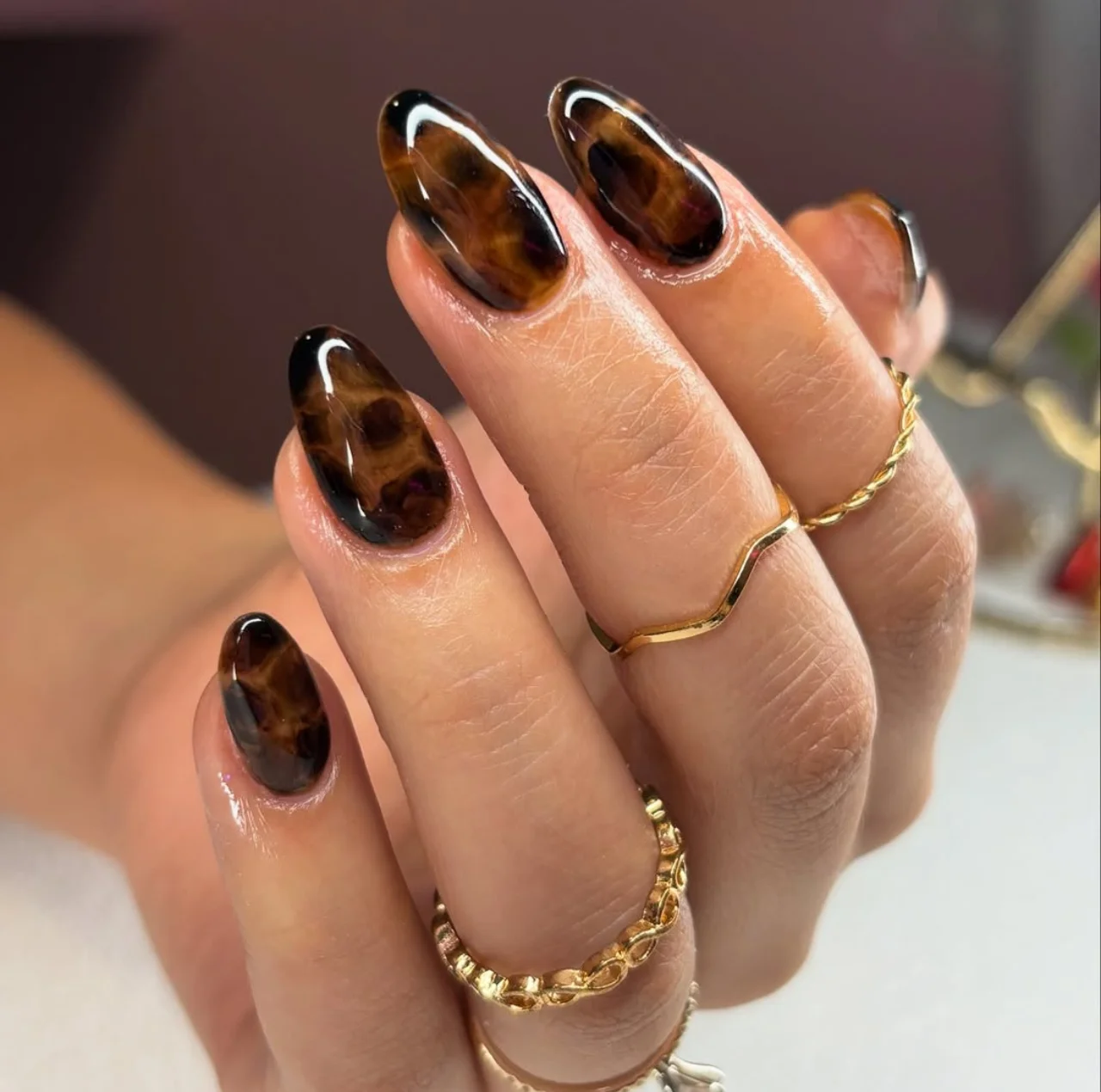 Diseños de uñas acrílicas tortoise nails con efecto carey en tonos marrón y negro.