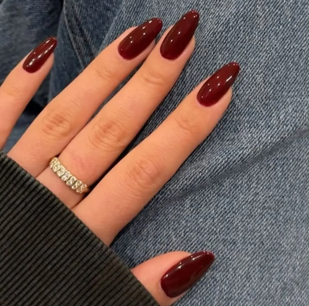 Diseños de uñas acrílicas color vino tinto con forma almendrada y acabado brillante.