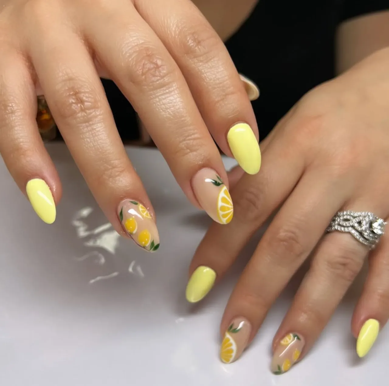 Diseño de uñas limonada con esmalte amarillo y decoraciones de rodajas de limón – diseños de uñas limonada.