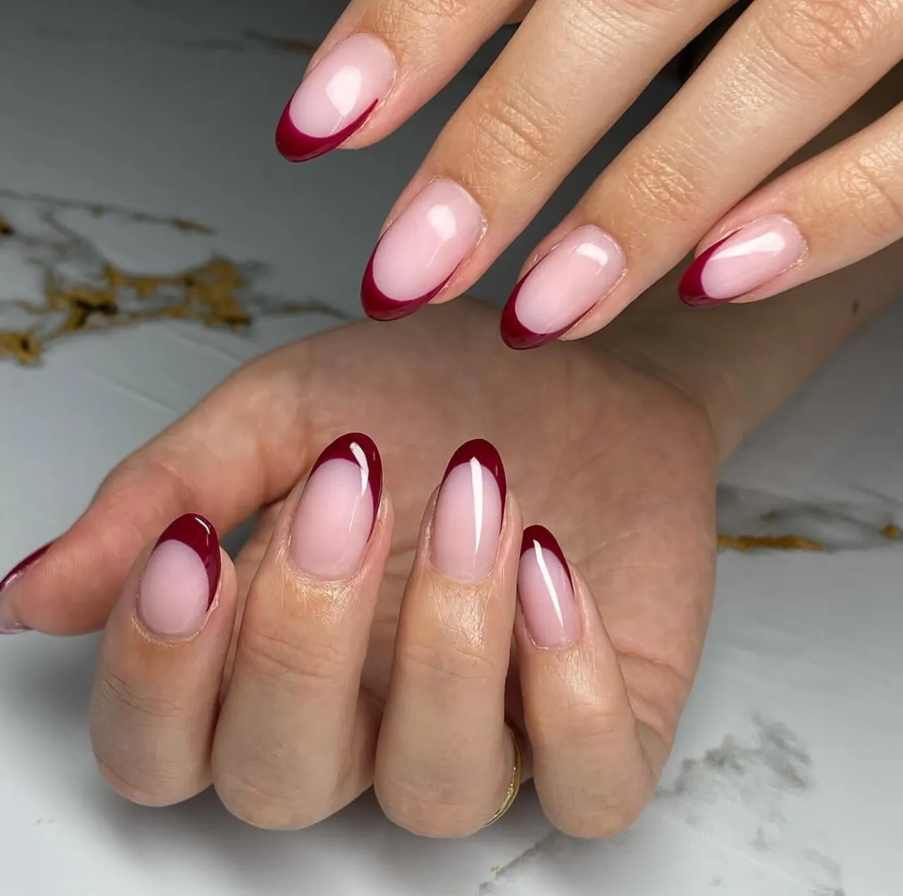 Diseño de uñas francesas burgundy con acabado brillante, tendencia elegante en uñas acrílicas.