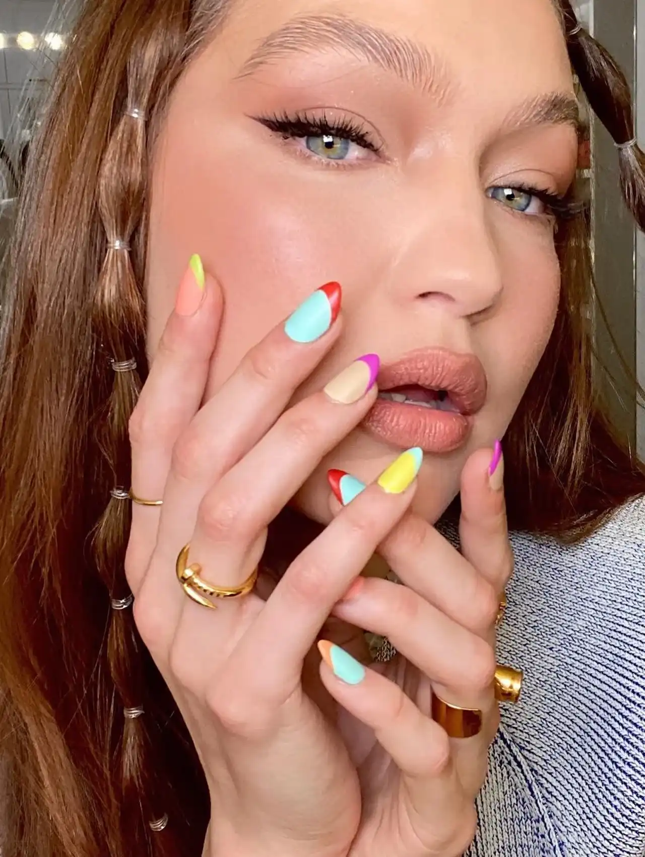 Gigi Hadid posing with colorful French tip celebrity nails in neon shades
