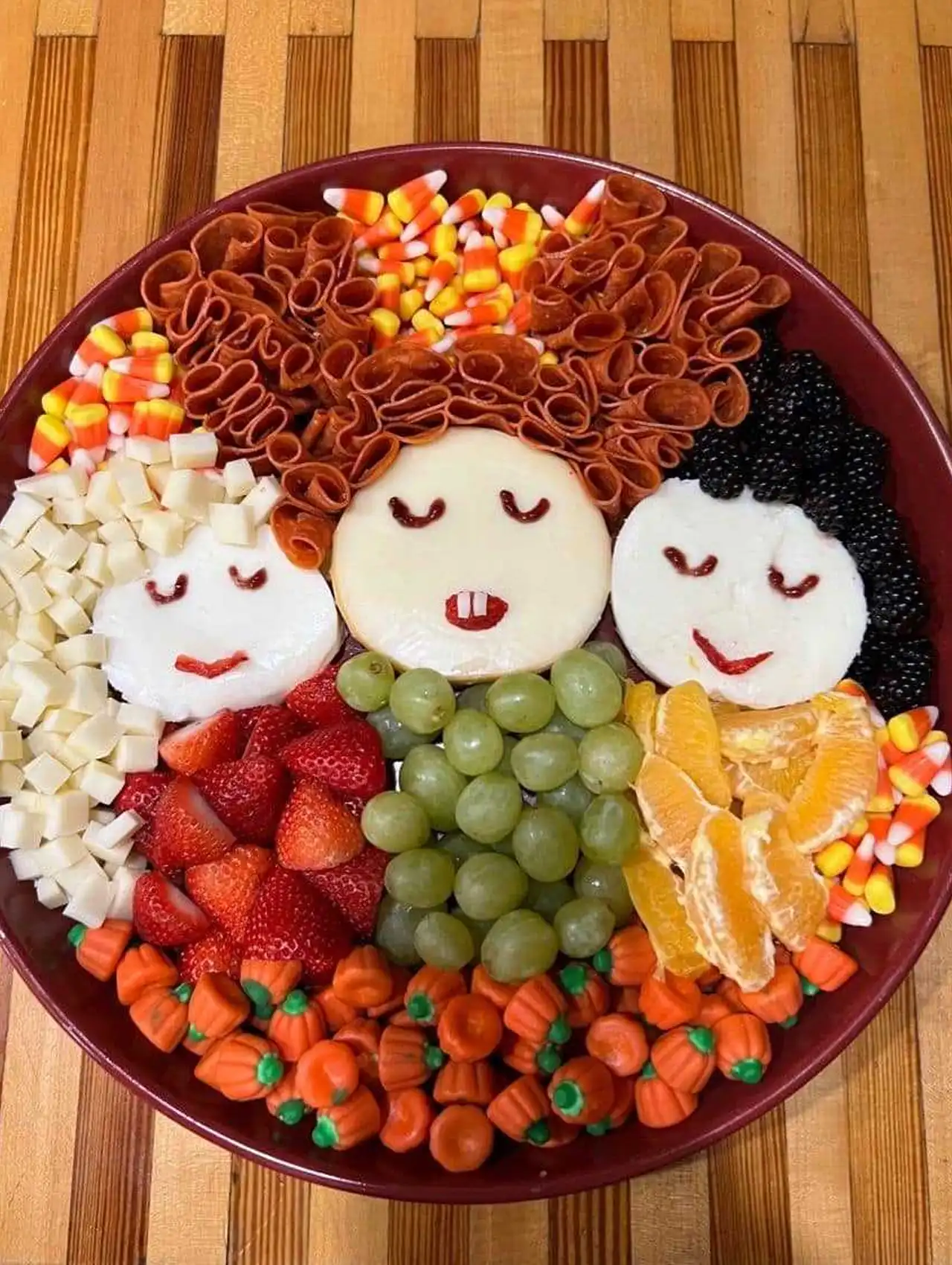 Hocus Pocus halloween charcuterie board with cheese faces, candy corn, and fruit.