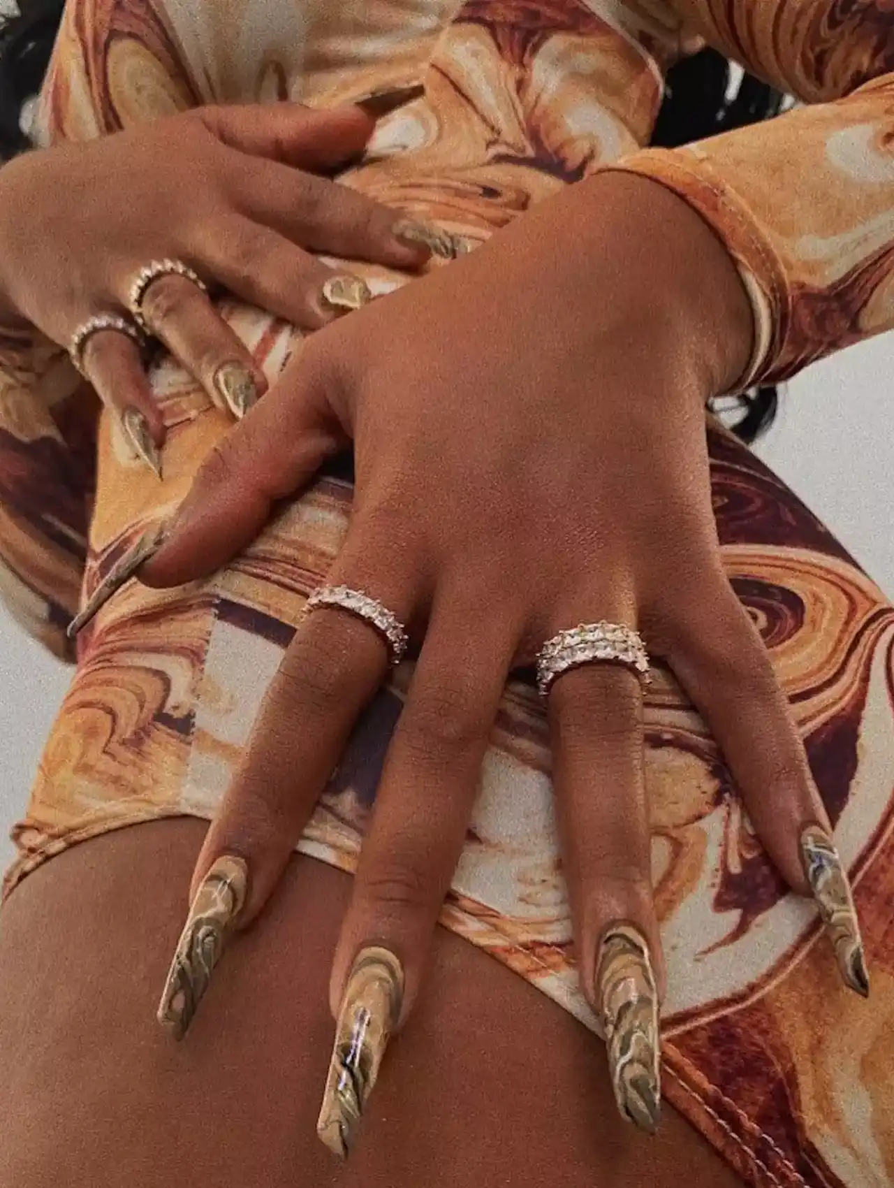 Megan Thee Stallion wearing long marble design celebrity nails in earthy tones