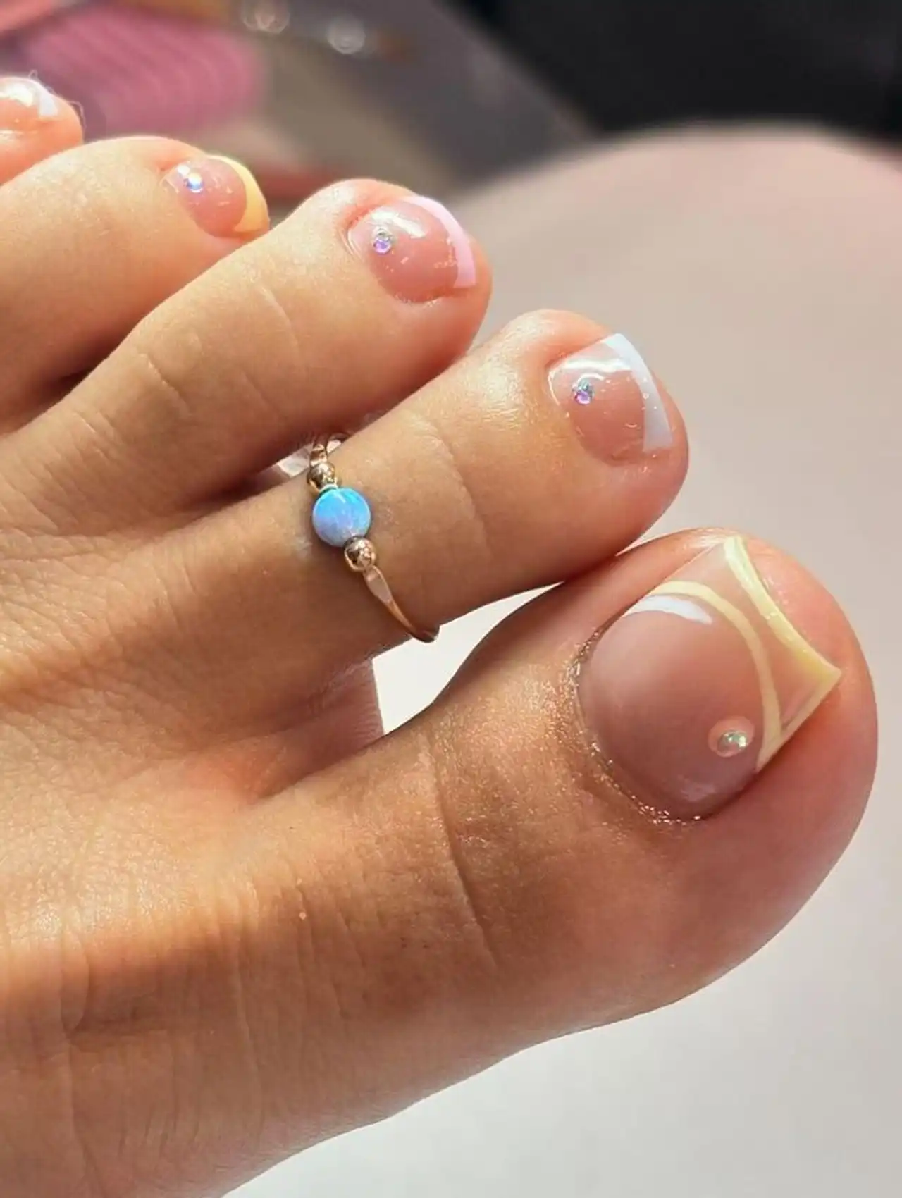 Minimalist French summer toe nail design with pearl accents and nude base