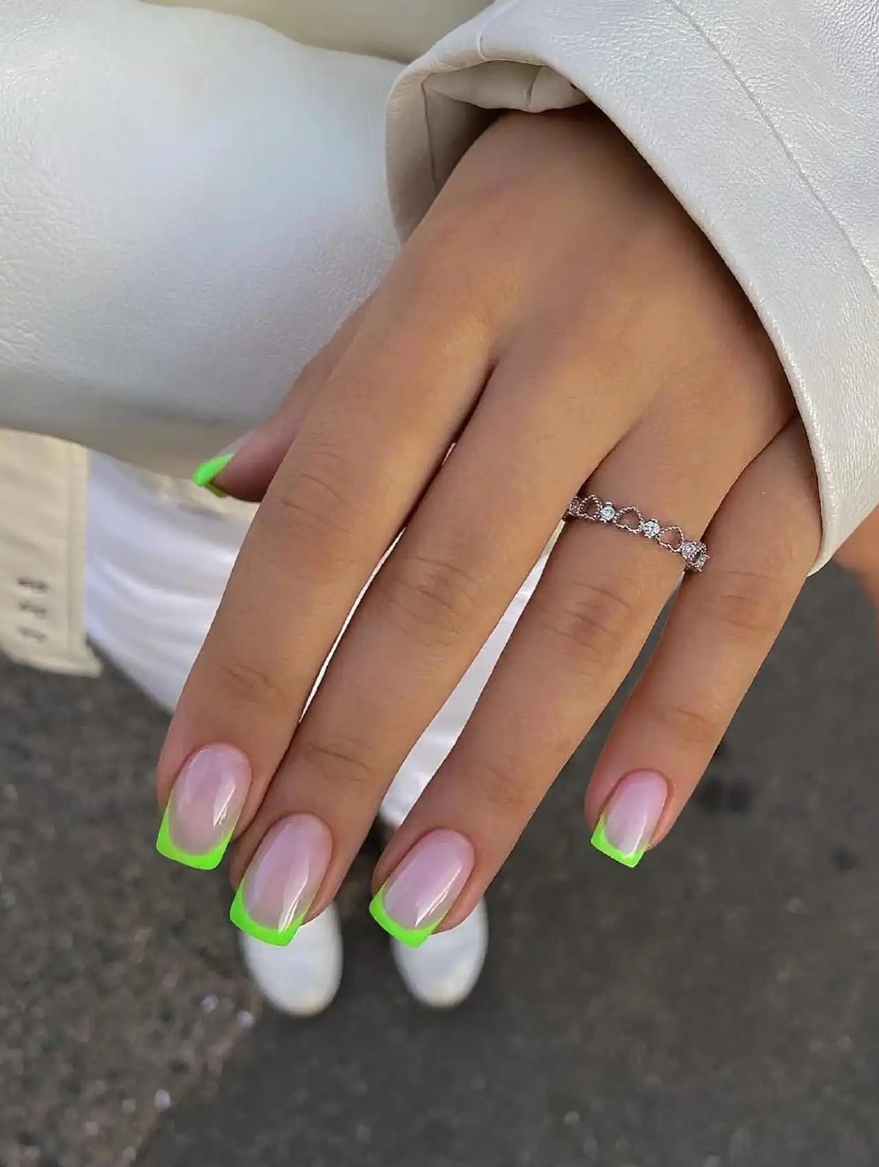 Neon green French tips on nude base, creating bold summer nail designs