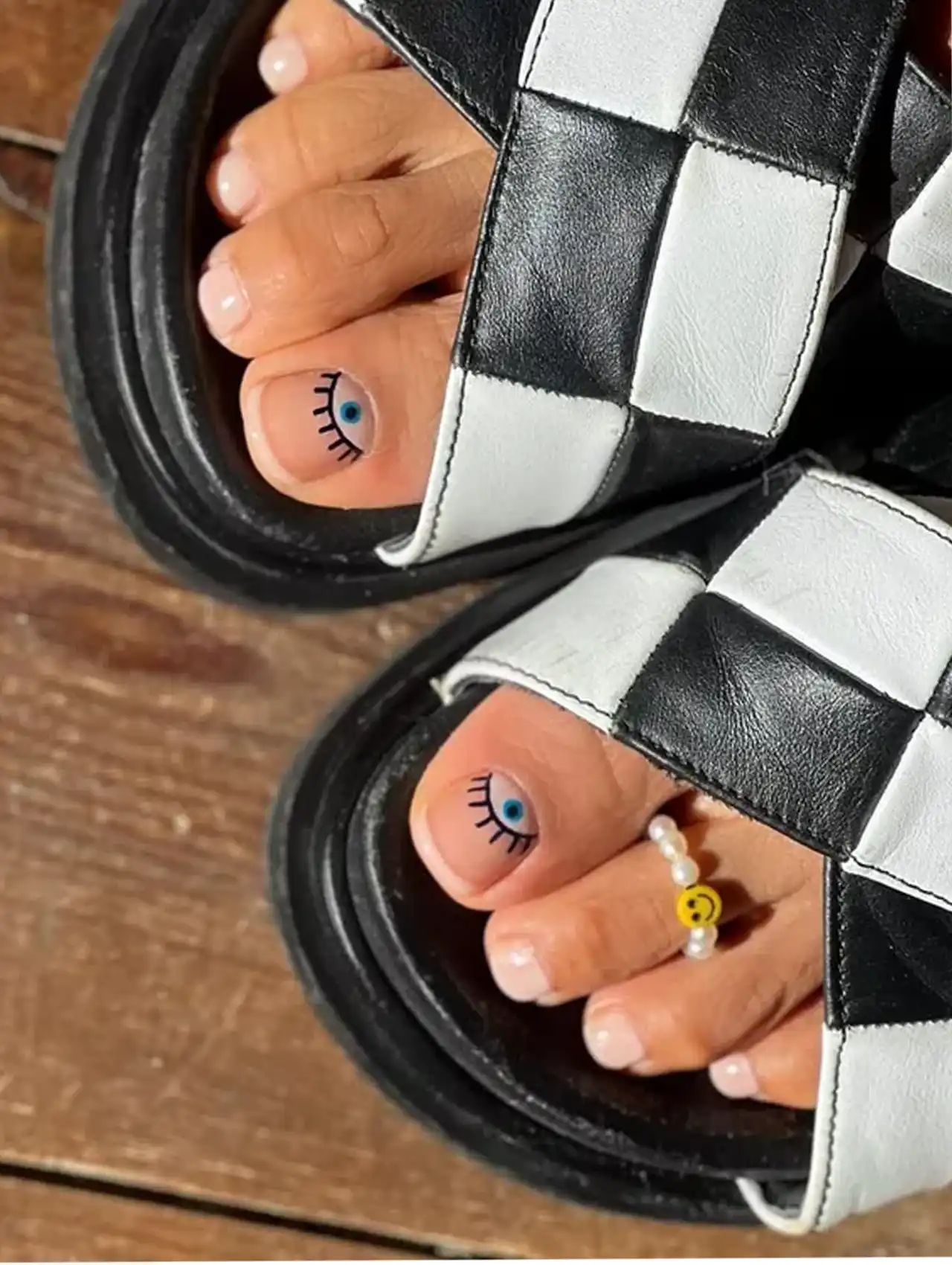 Neutral summer toe nail design with blue eye accent art