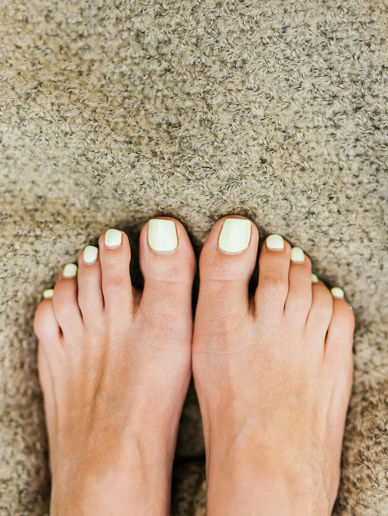 Pale yellow summer toe nail design with glossy finish