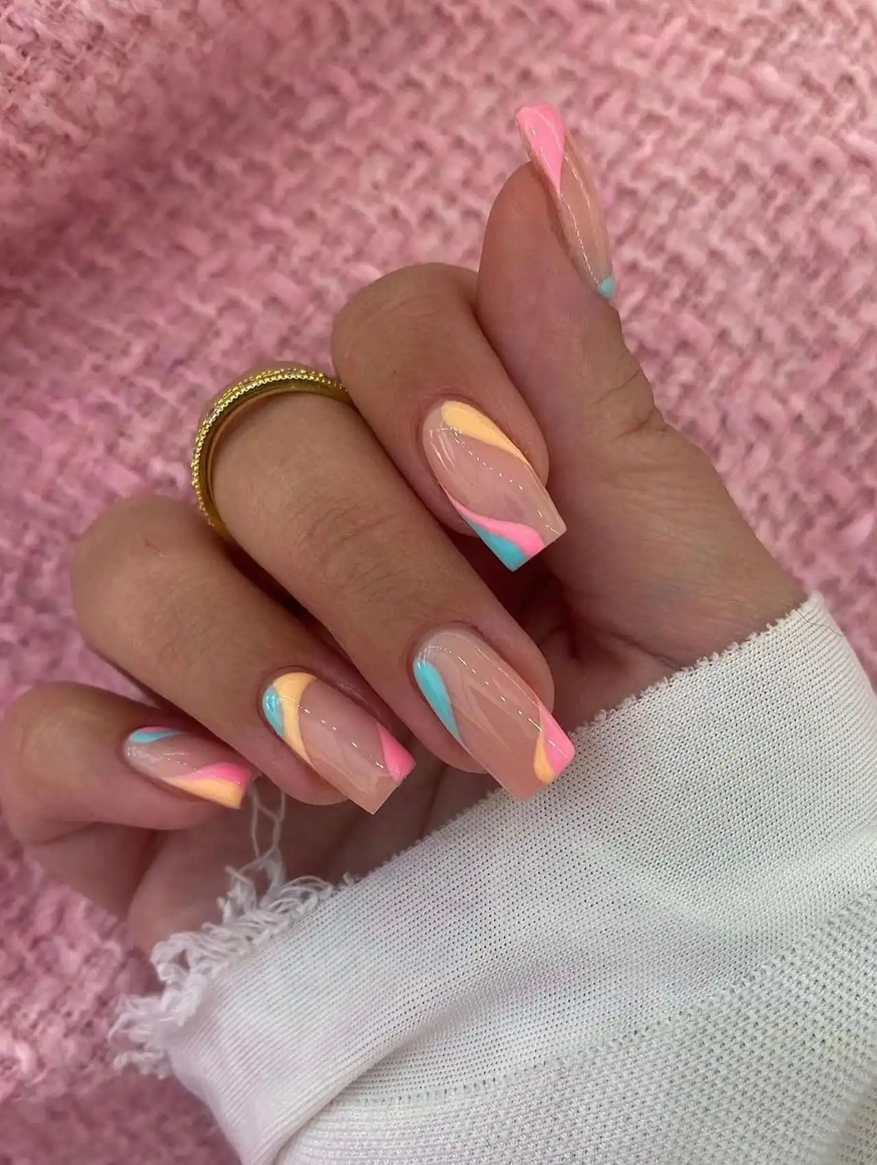 Swirled pastel nails in peach, pink, and blue for trendy summer nail designs