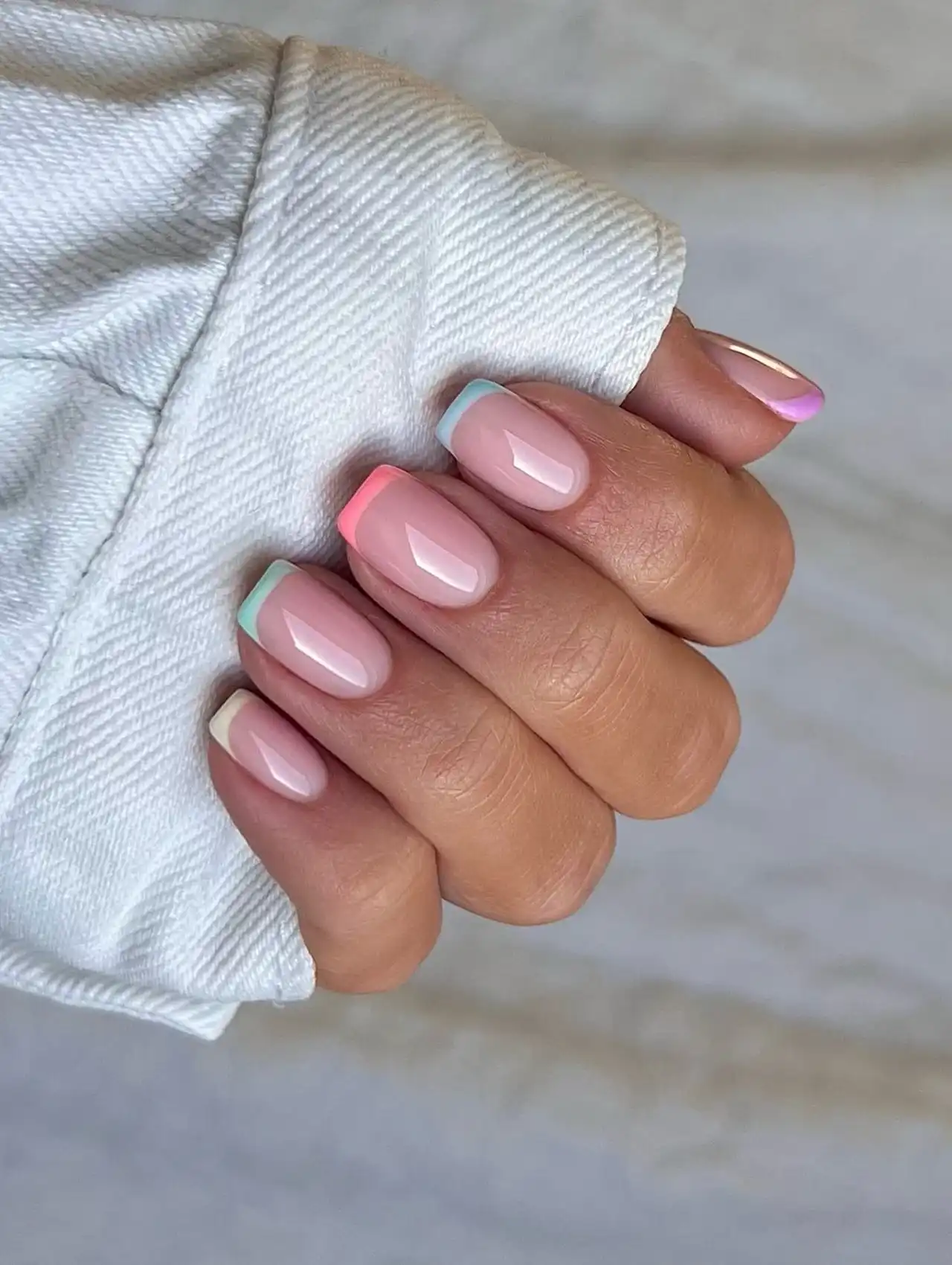 Pastel French tip nails in various shades, including pink, blue, and lavender, for summer nail designsPastel French tip nails in various shades, including pink, blue, and lavender, for summer nail designs