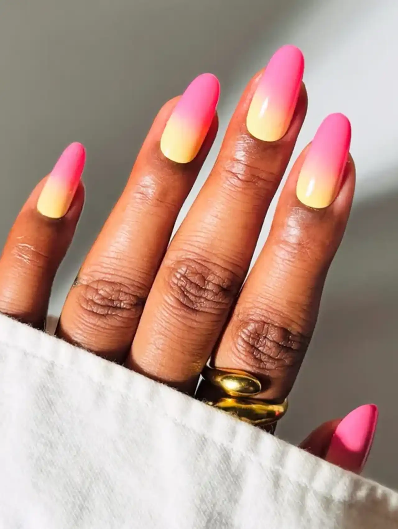 Gradient pink and yellow ombré nails for vibrant summer nail design