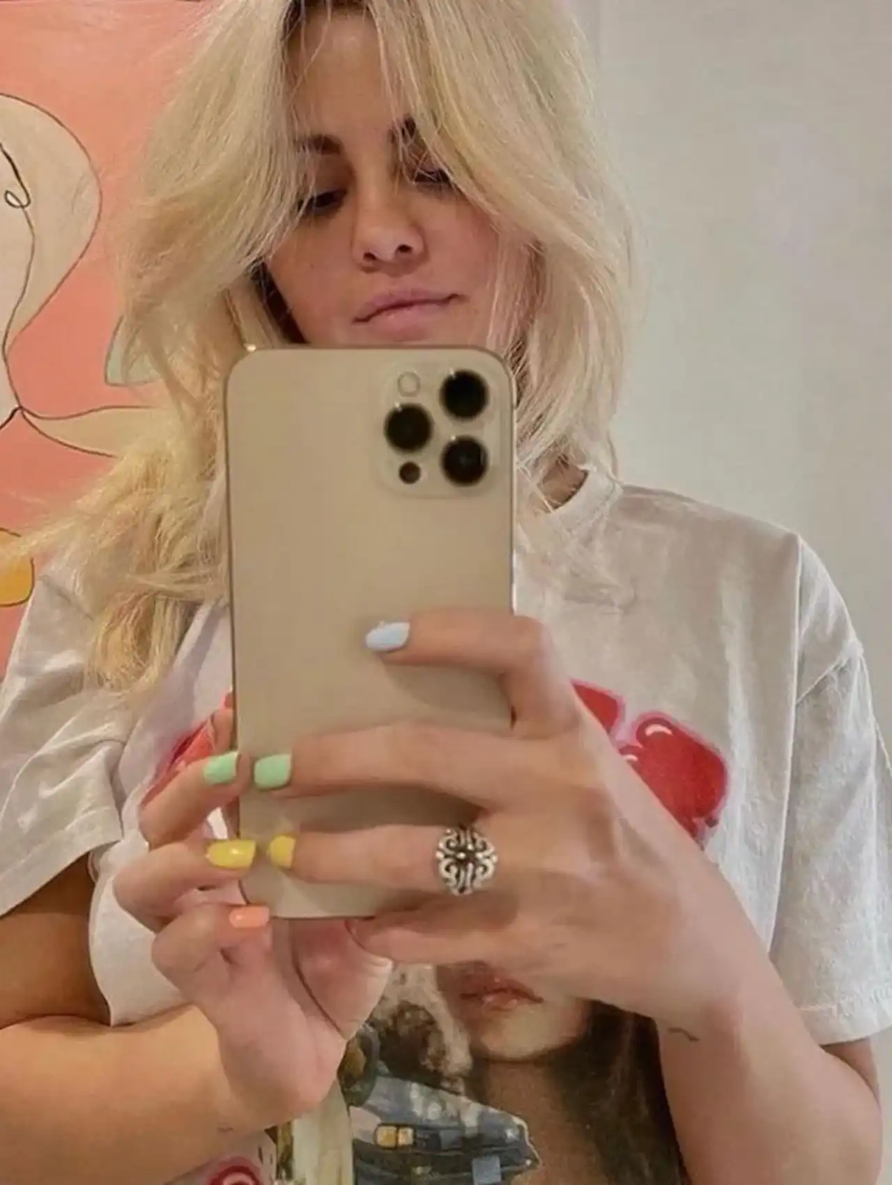 Selena Gomez showing pastel Skittles-style celebrity nails in a mirror selfie
