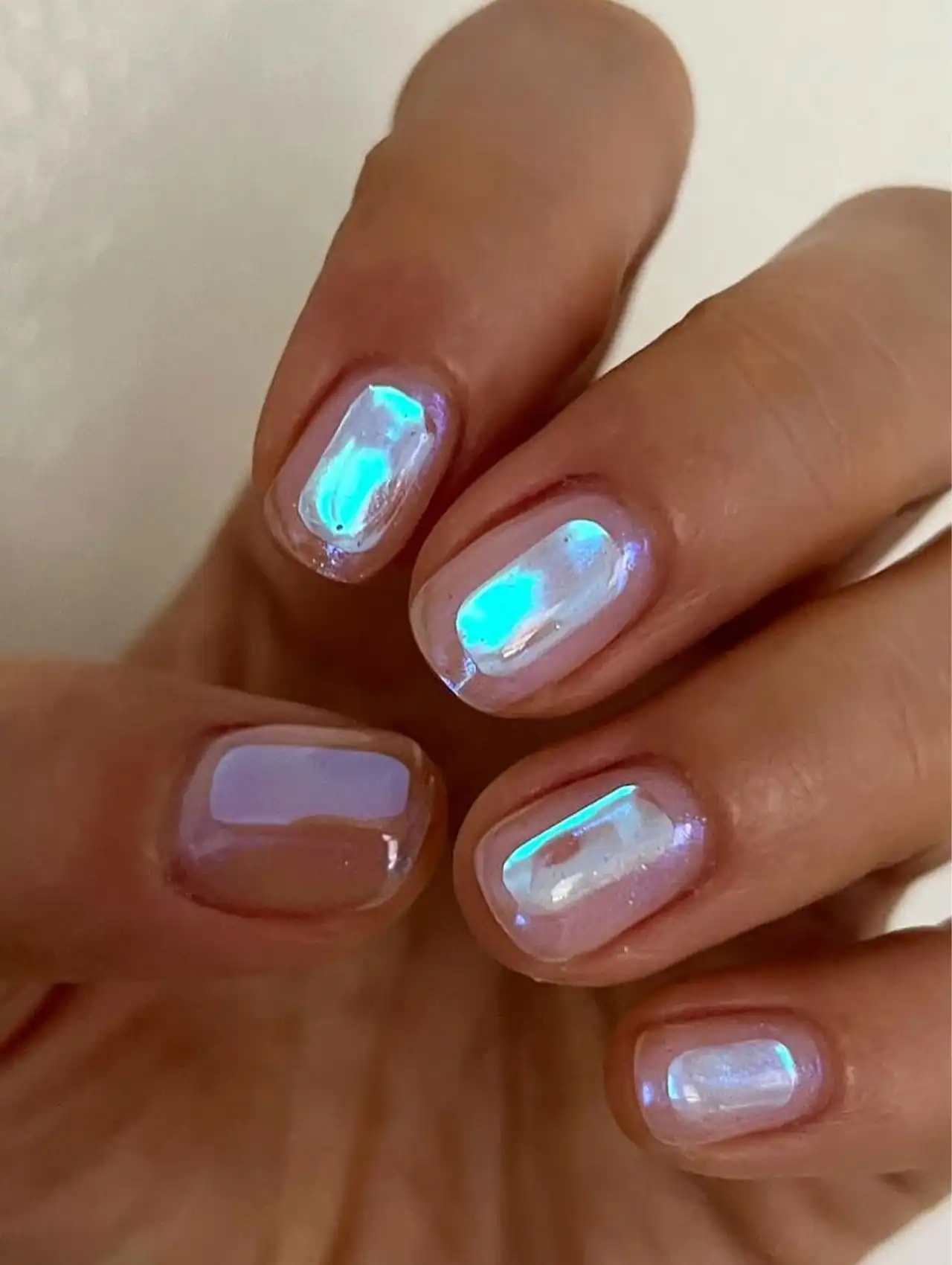 White chrome nails with blue reflective shine showcasing aurora nail design ideas