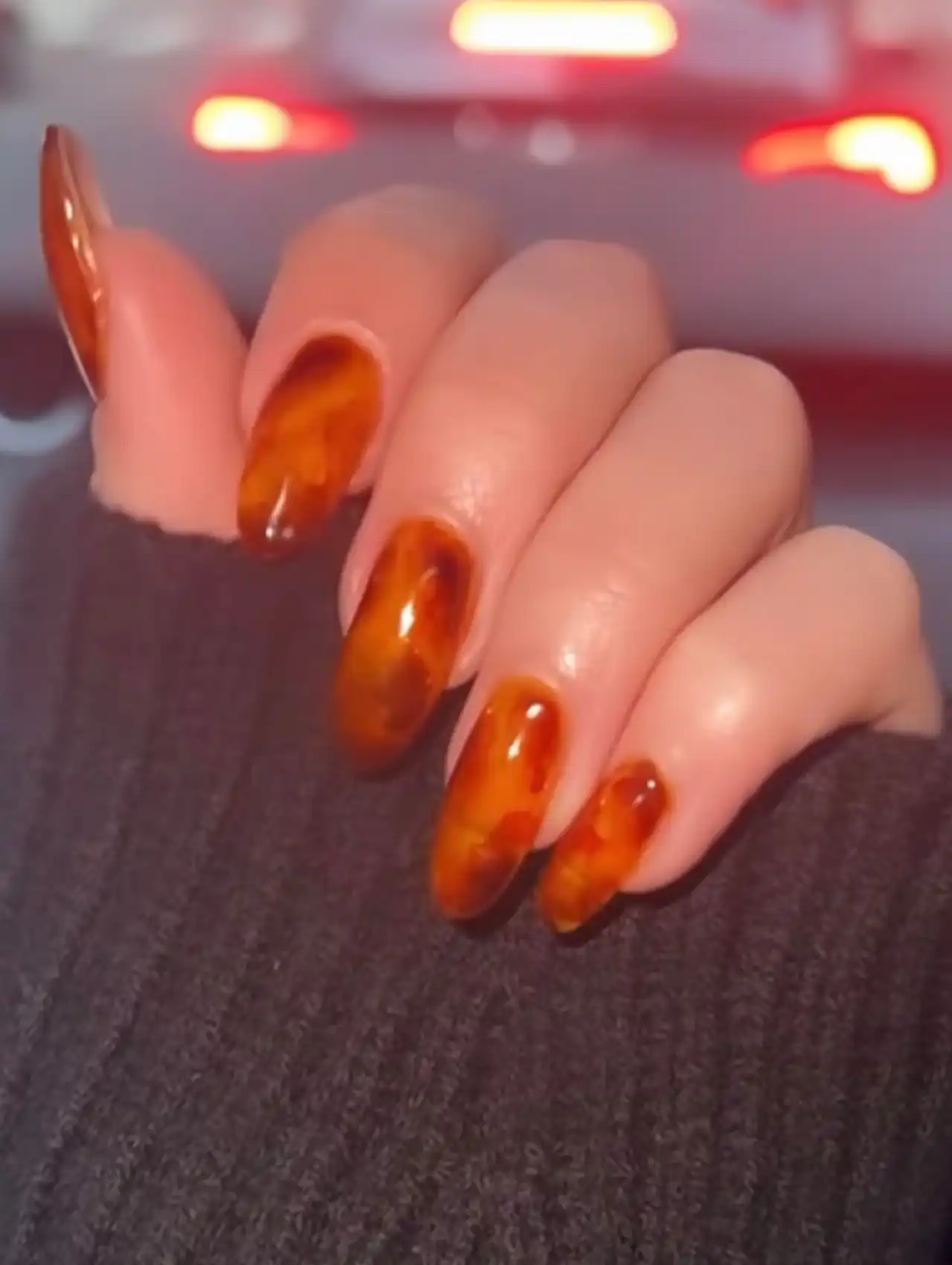 Sydney Sweeney with glossy brown tortoise-shell celebrity nails