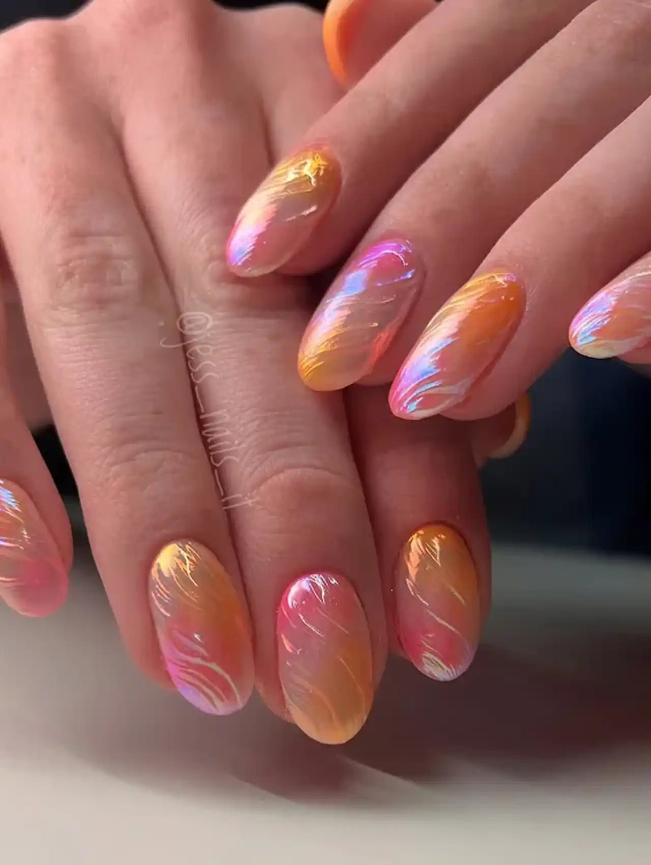 Bright orange and pink textured chrome nails showcasing aurora nail design ideas