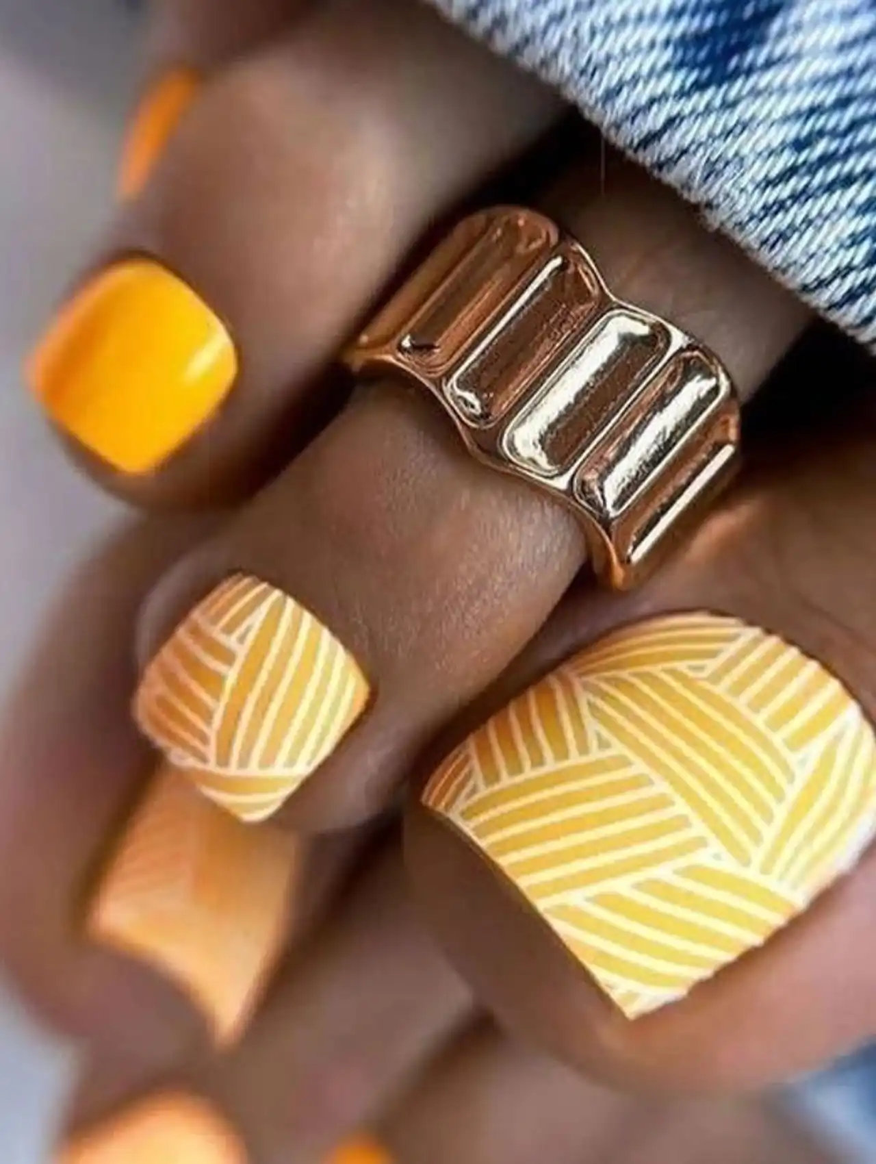 Yellow patterned summer toe nail design with geometric lines