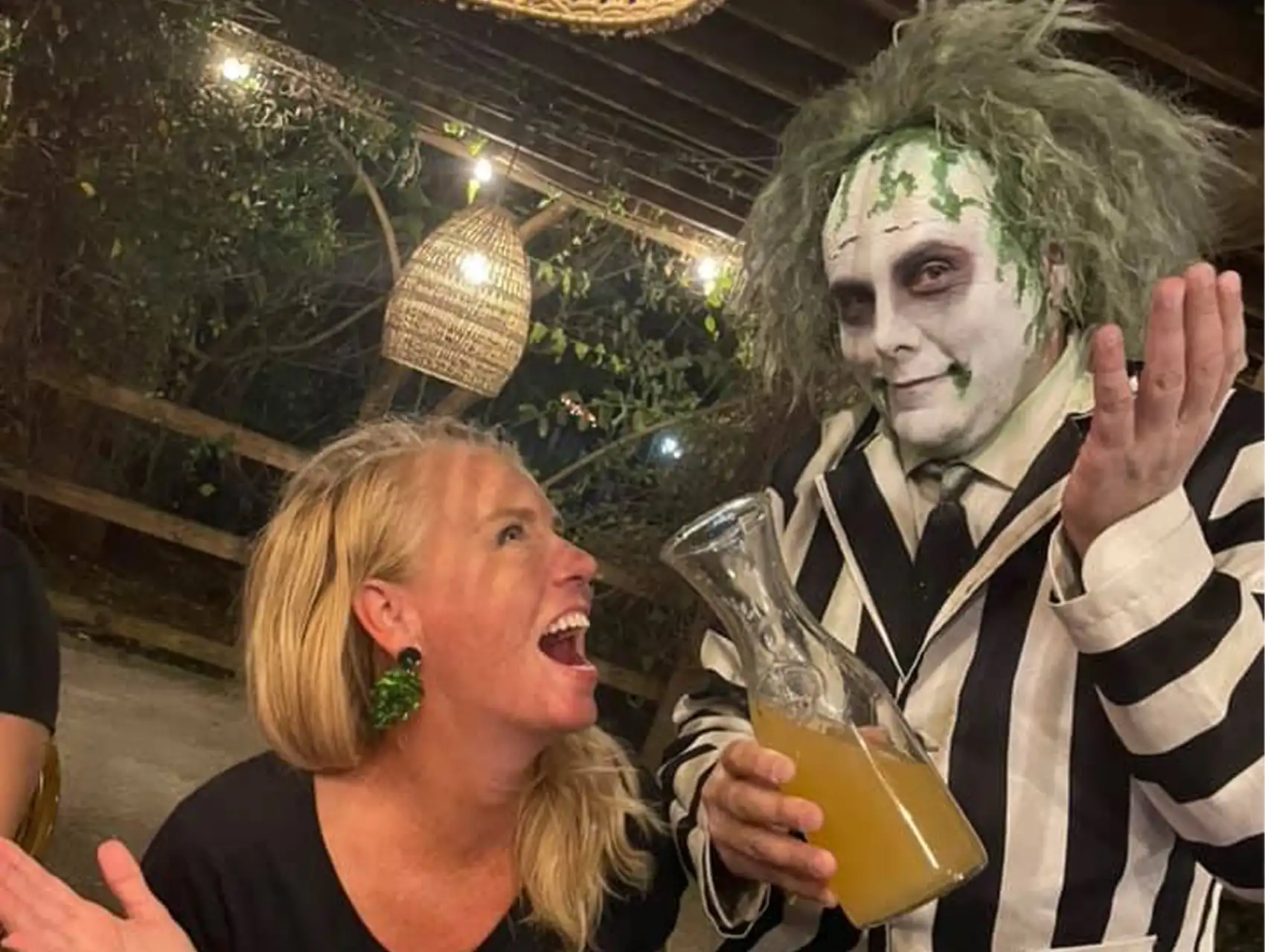 Person dressed as Beetlejuice serving drinks at an Orlando bar during a halloween bar crawl.