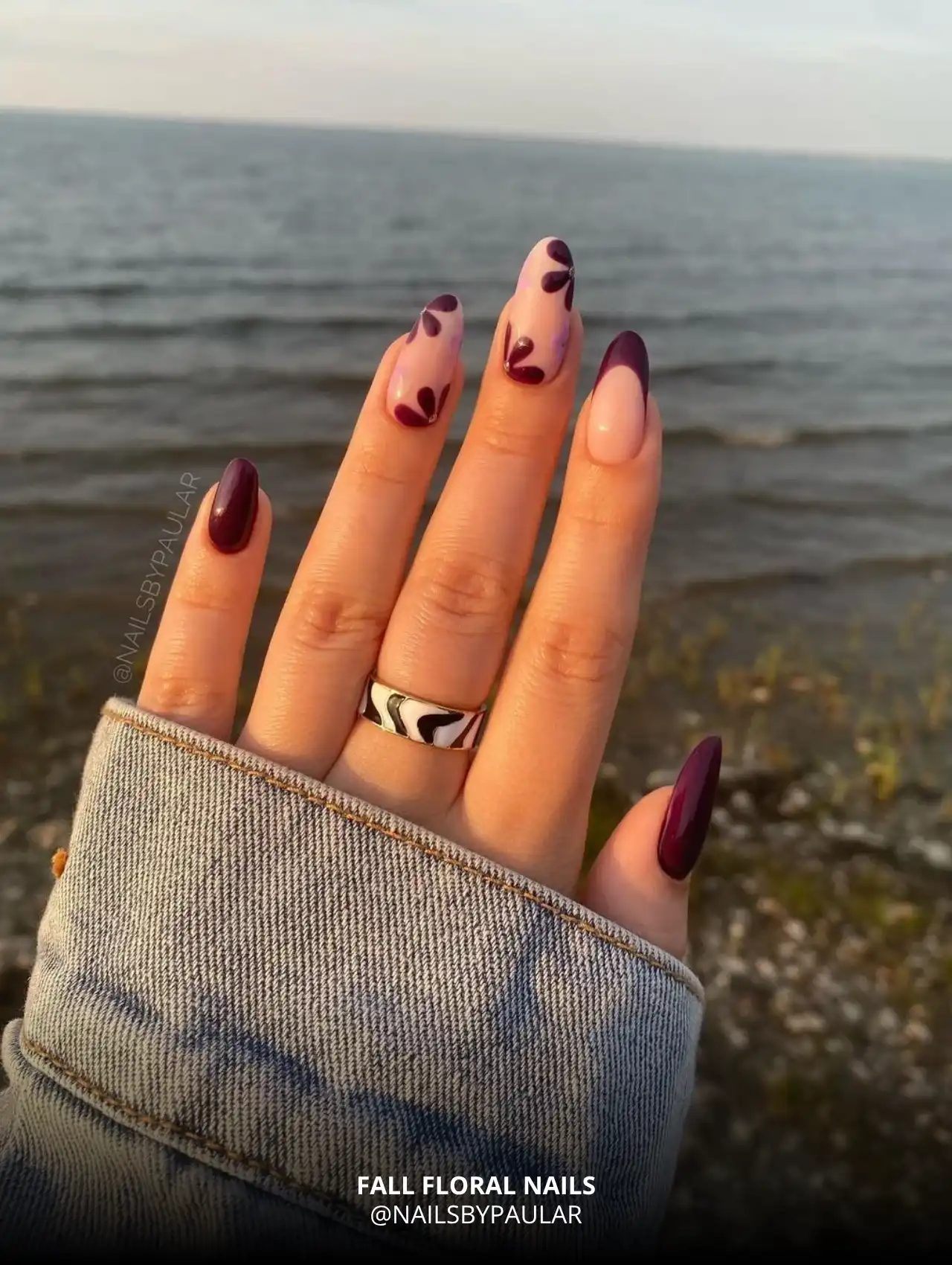 Fall floral nail design with purple leaf patterns.